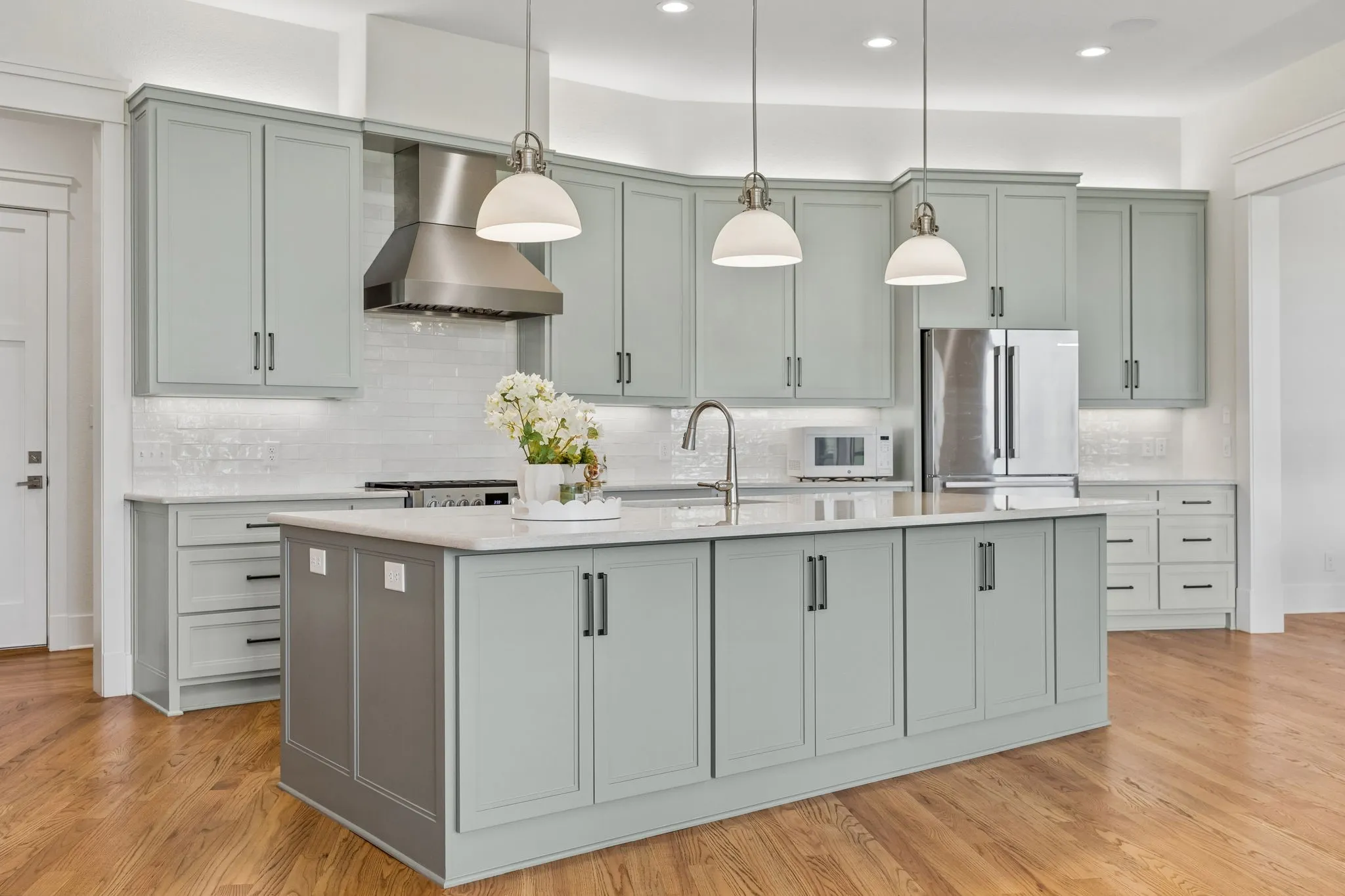 The gourmet kitchen is fully equipped with a 6-burner commercial-grade range and hood, custom shaker cabinetry, white subway tile backsplash, built-in hutch, walk-in pantry, and large center island with breakfast bar seating.