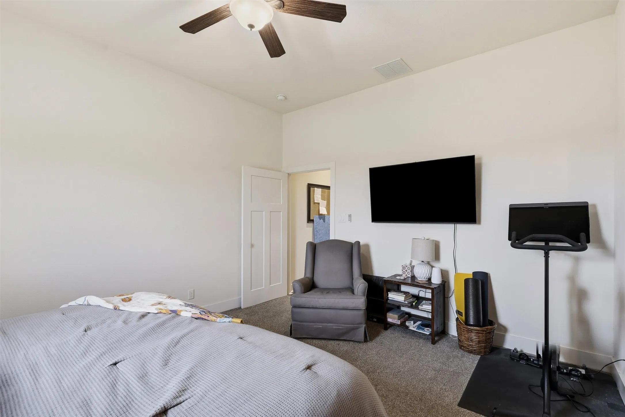 Spacious room featuring neutral carpeting, a ceiling fan, and white walls