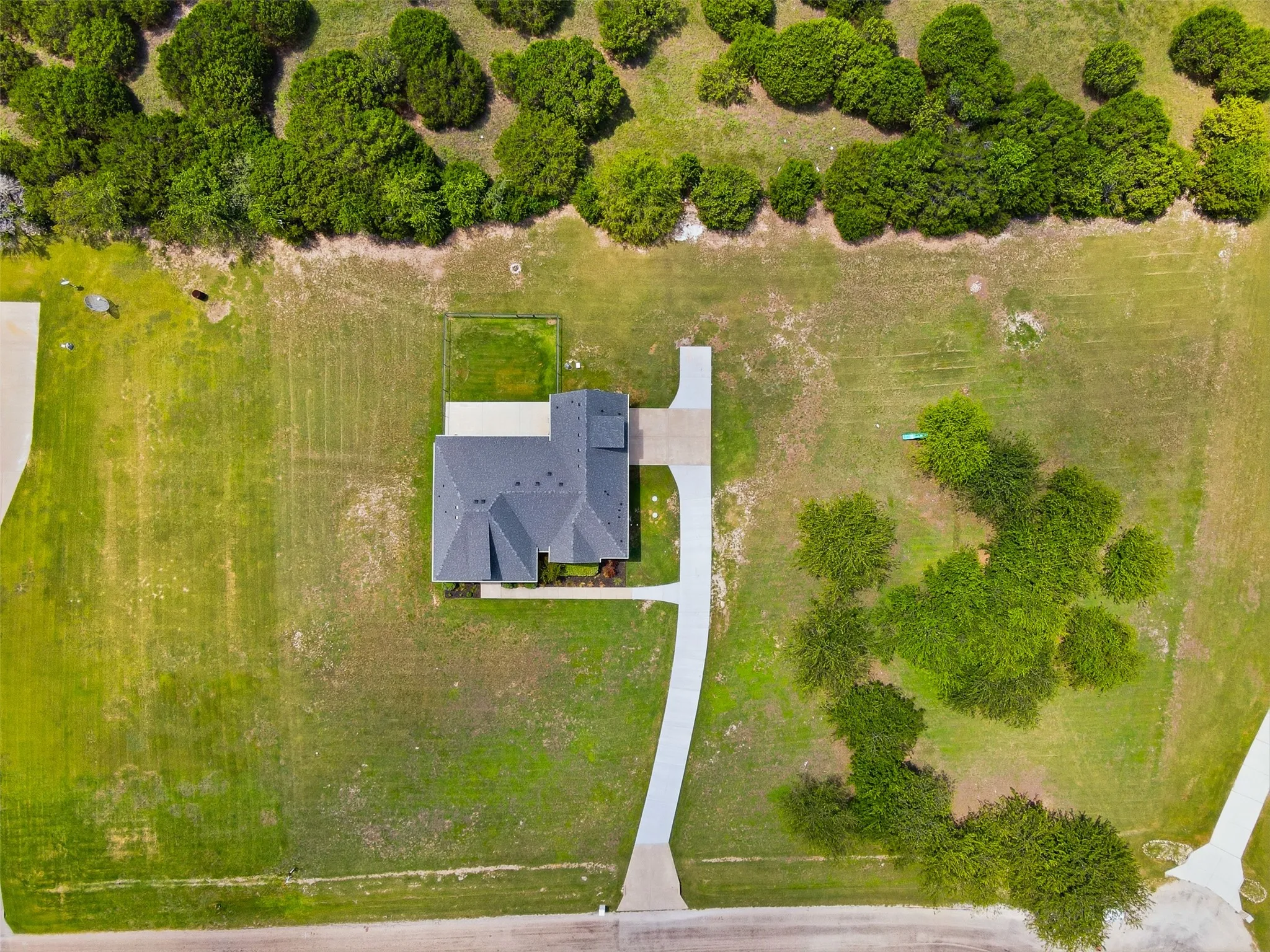 Aerial perspective showcasing a single-story residence with a dark gray shingle roof