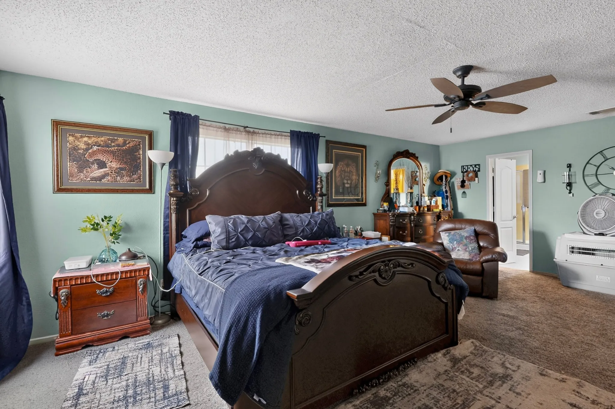 Spacious room featuring light green walls, a ceiling fan with integrated lighting, and carpeted flooring