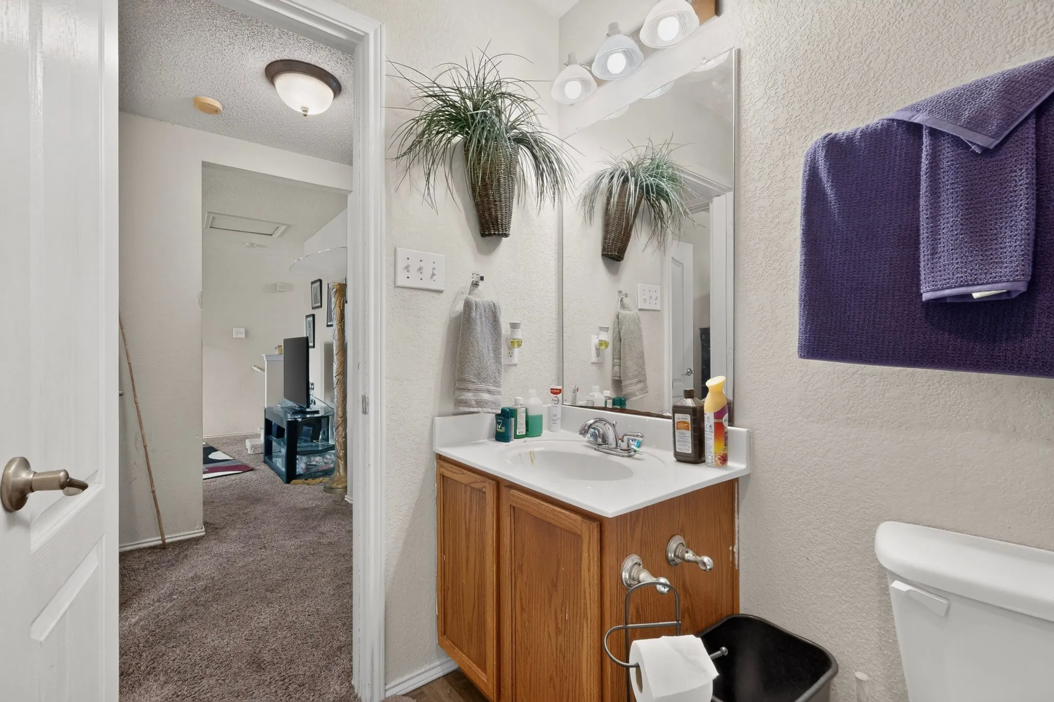 Bathroom vanity featuring a single basin sink, laminate countertop, and wood-finish cabinetry