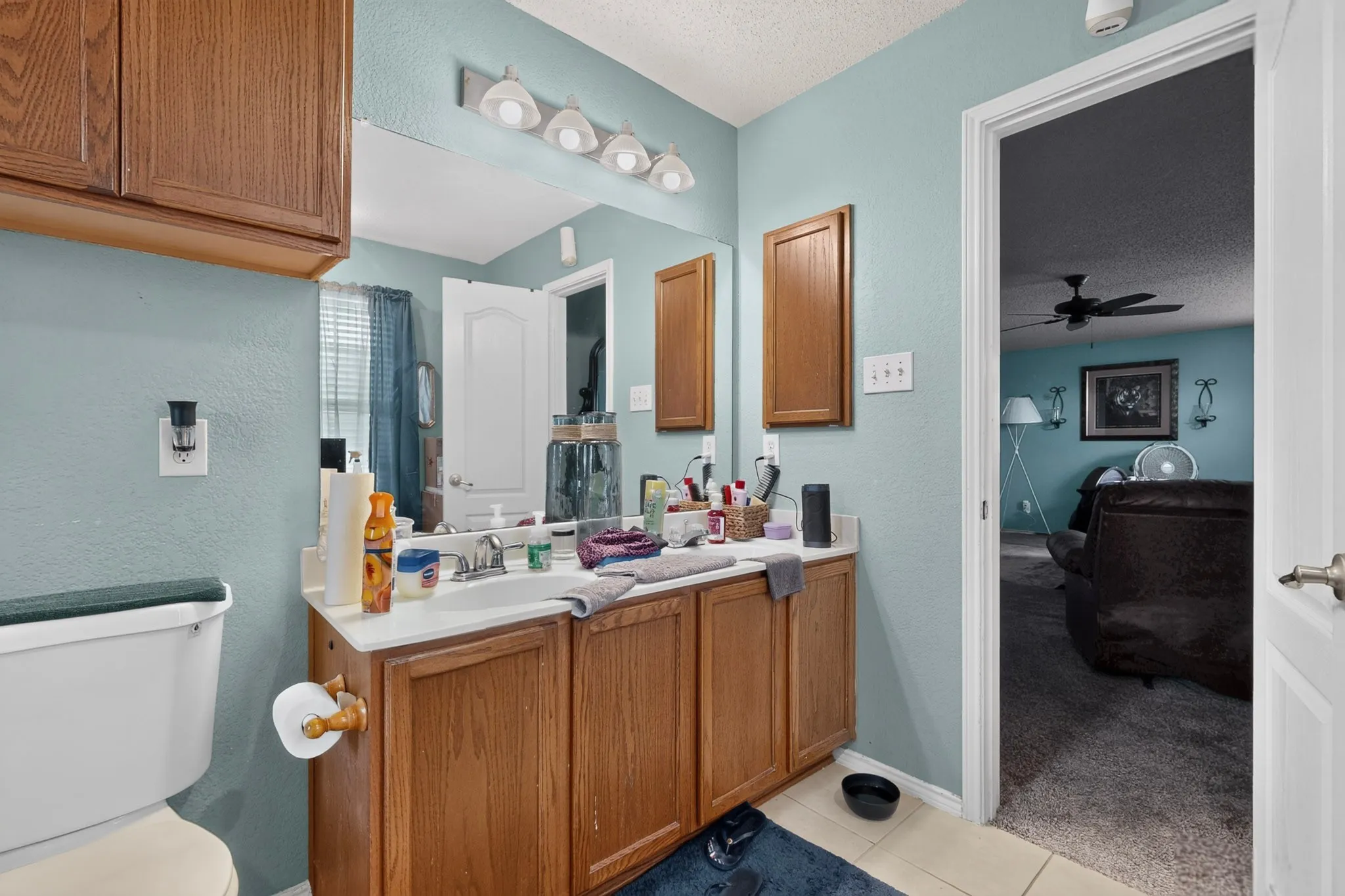 Bathroom featuring a wood-finish vanity with an integrated sink and a white countertop