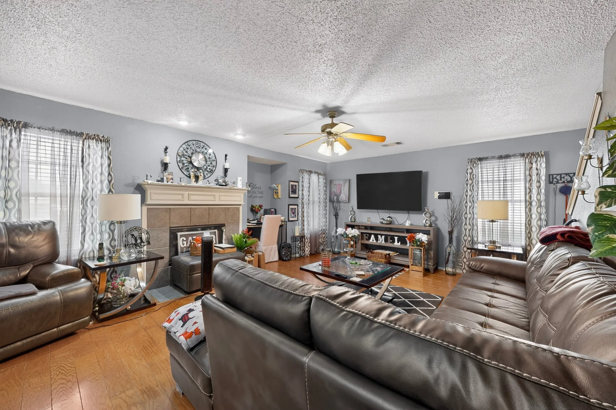 Living area featuring wood-finish flooring, a ceiling fan with integrated lighting, and recessed ceiling lights