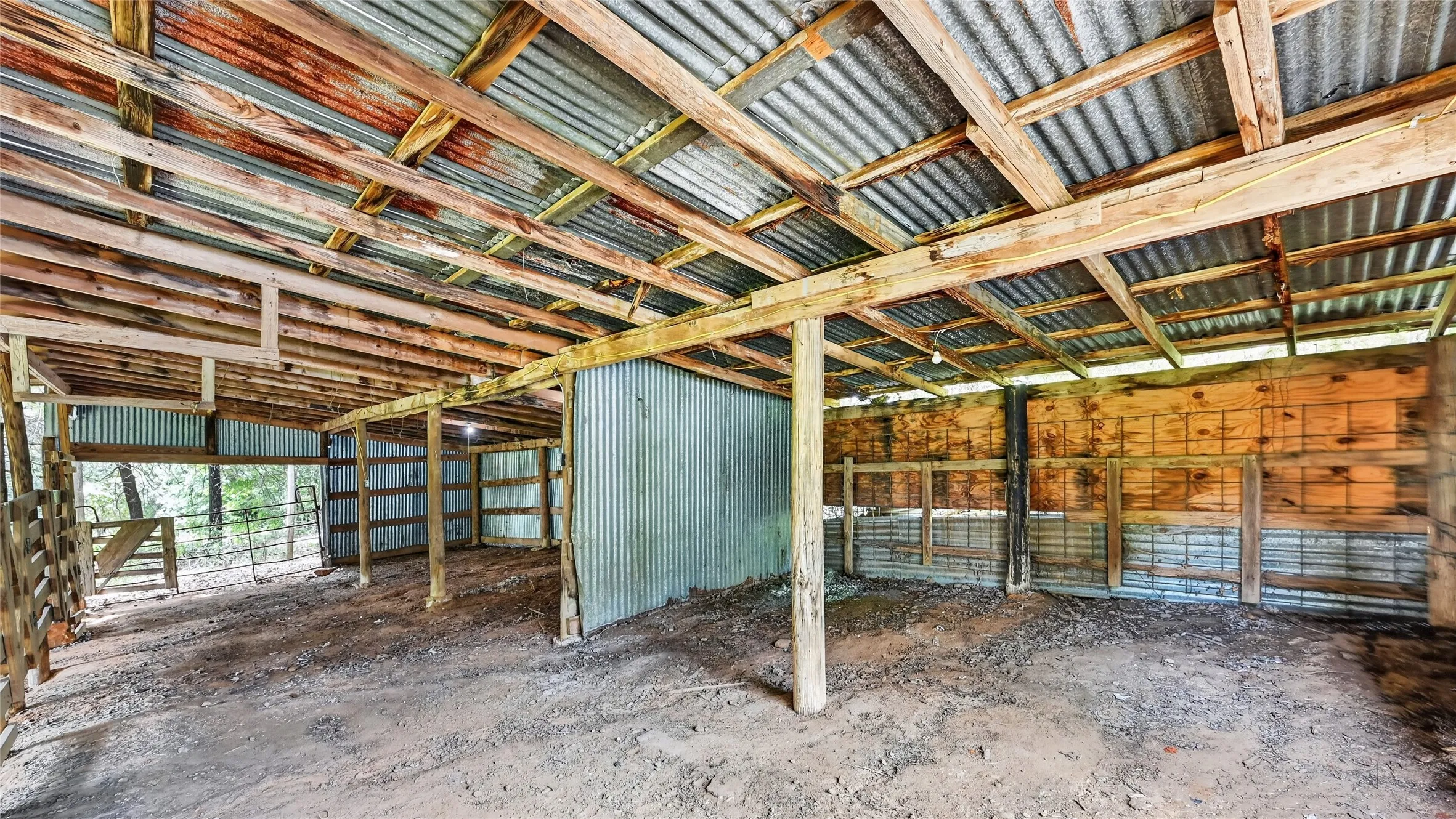 Spacious barn interior featuring high ceilings, timber-frame construction, and ample natural light, currently utilized as a versatile workshop and storage space.
