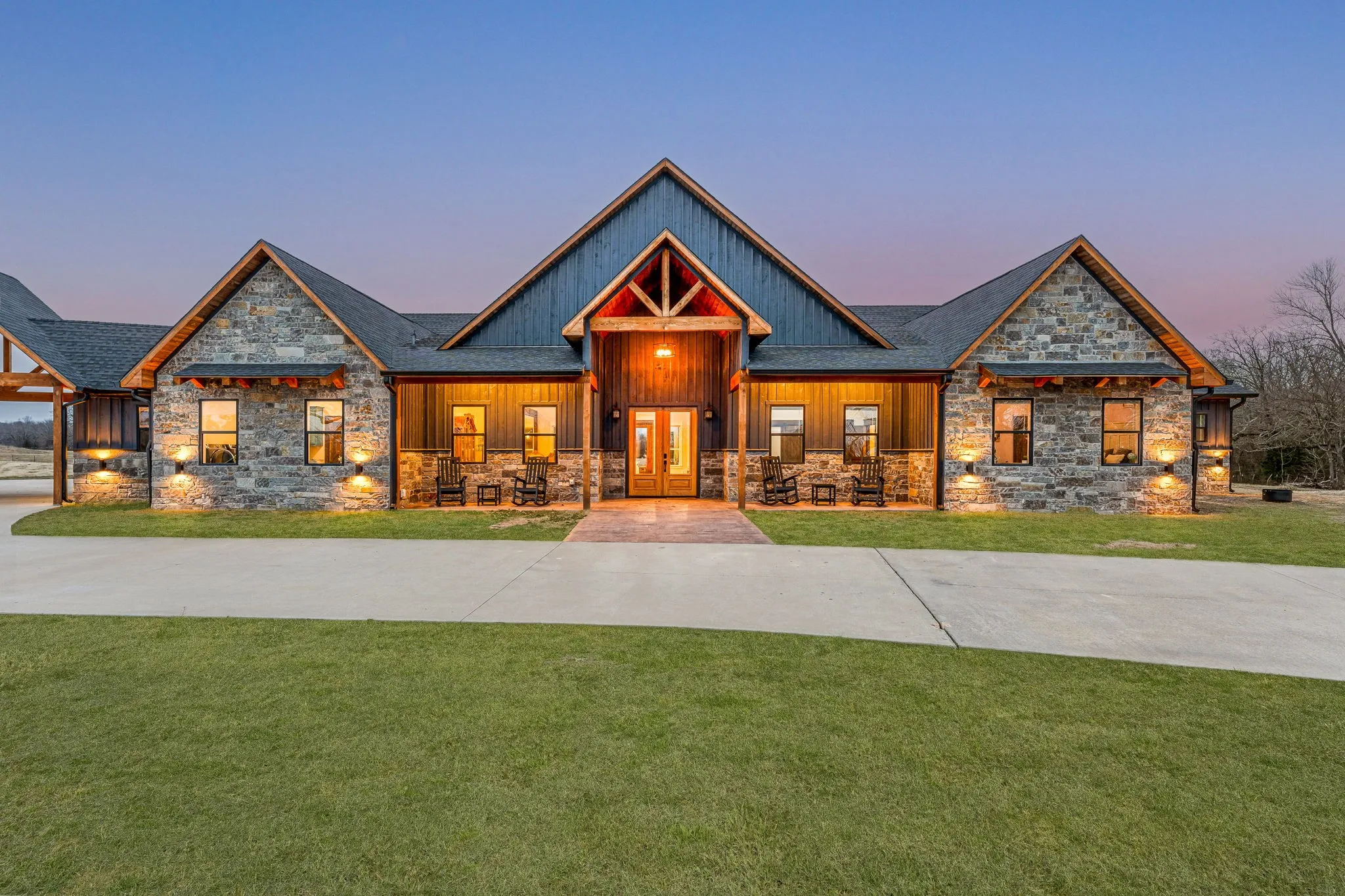 Craftsman-style home with a porch, stone siding, and a front lawn