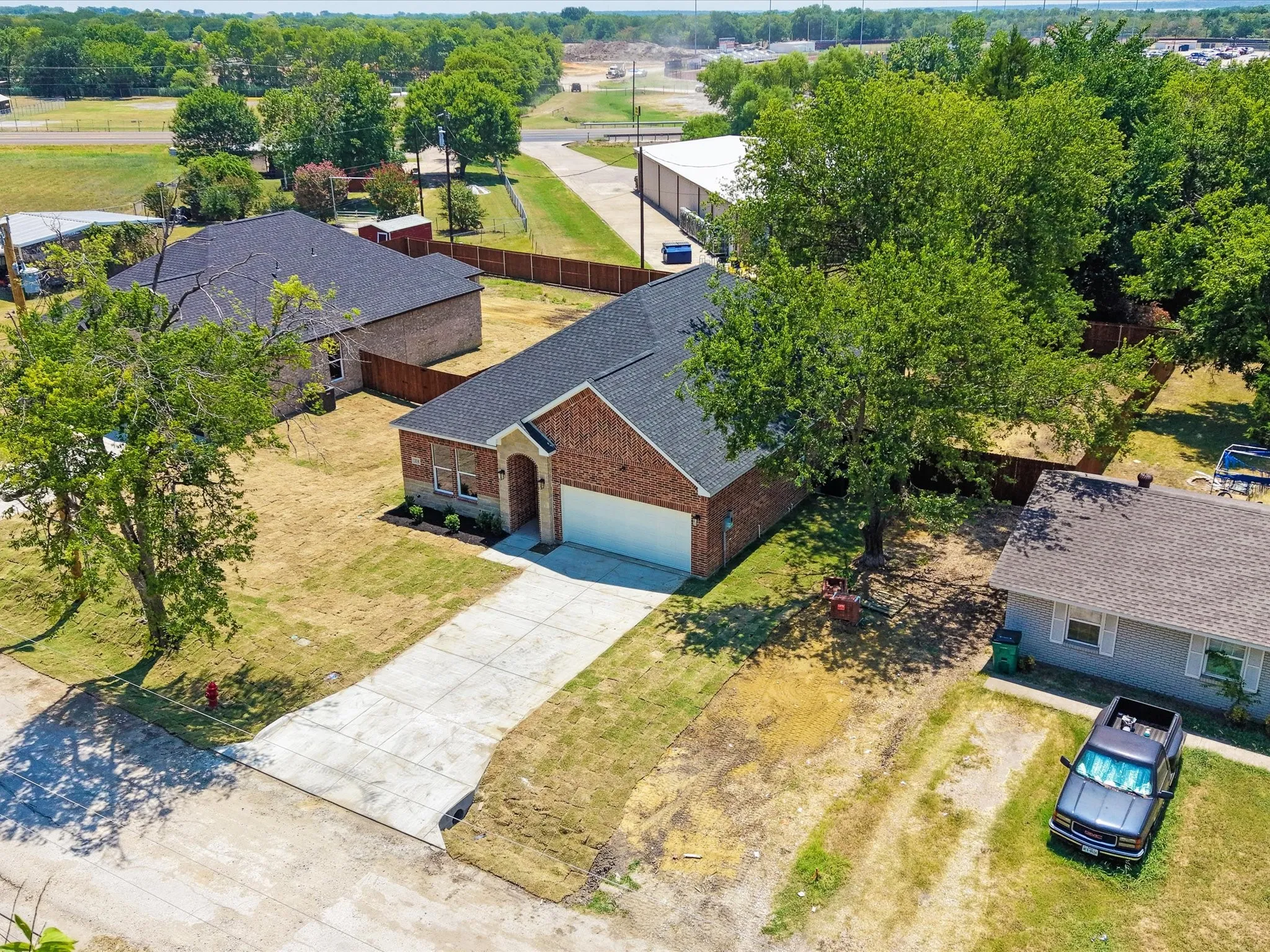 Brick exterior with a dark shingle roof, attached garage, and concrete driveway