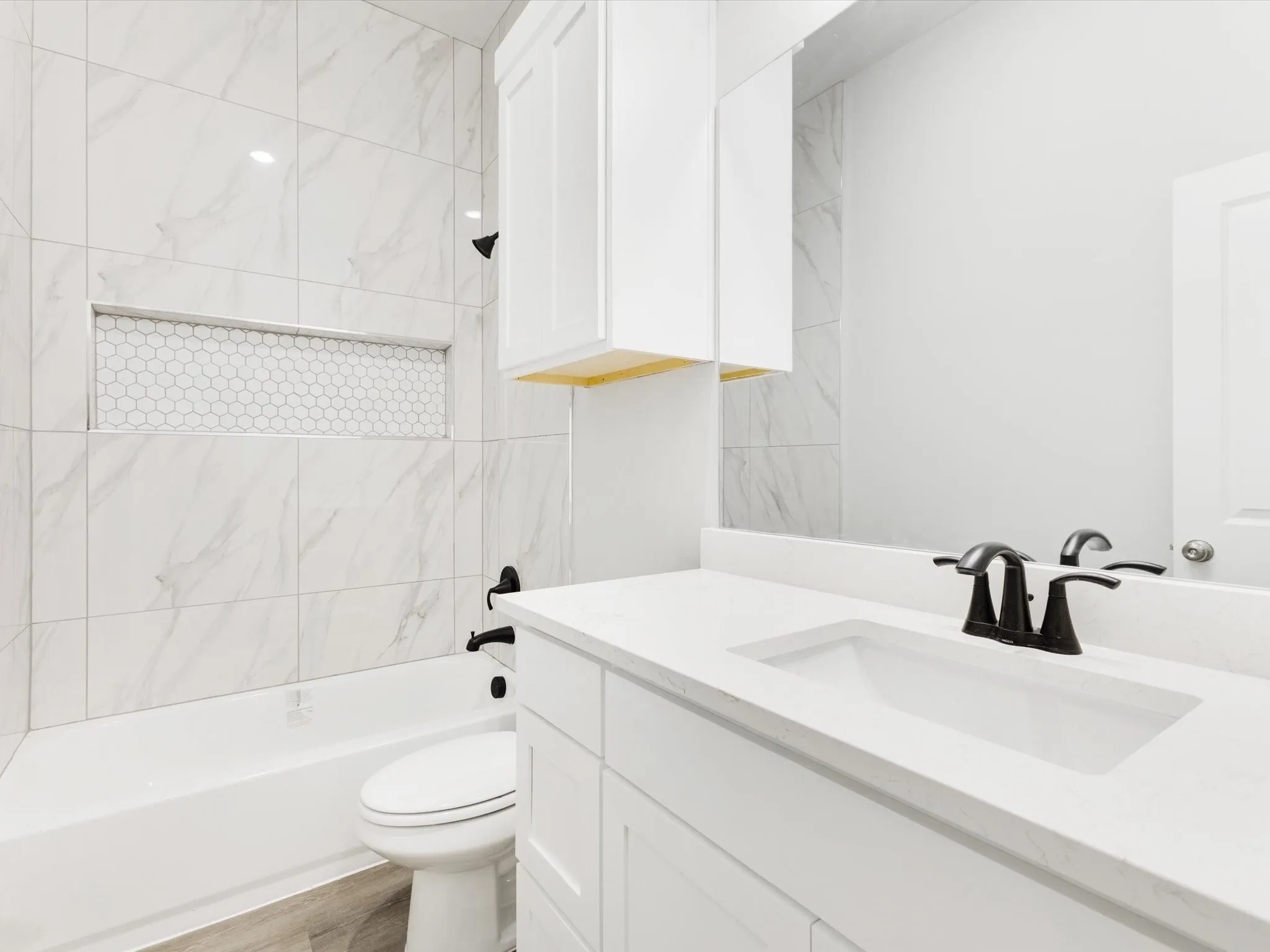 White bathroom vanity with an integrated rectangular sink, matte black faucet, and white shaker-style cabinetry