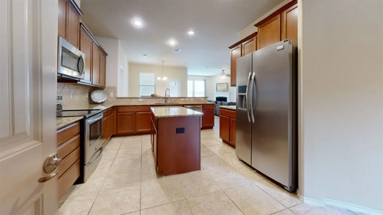 Granite kitchen with island, fridge conveys with property.