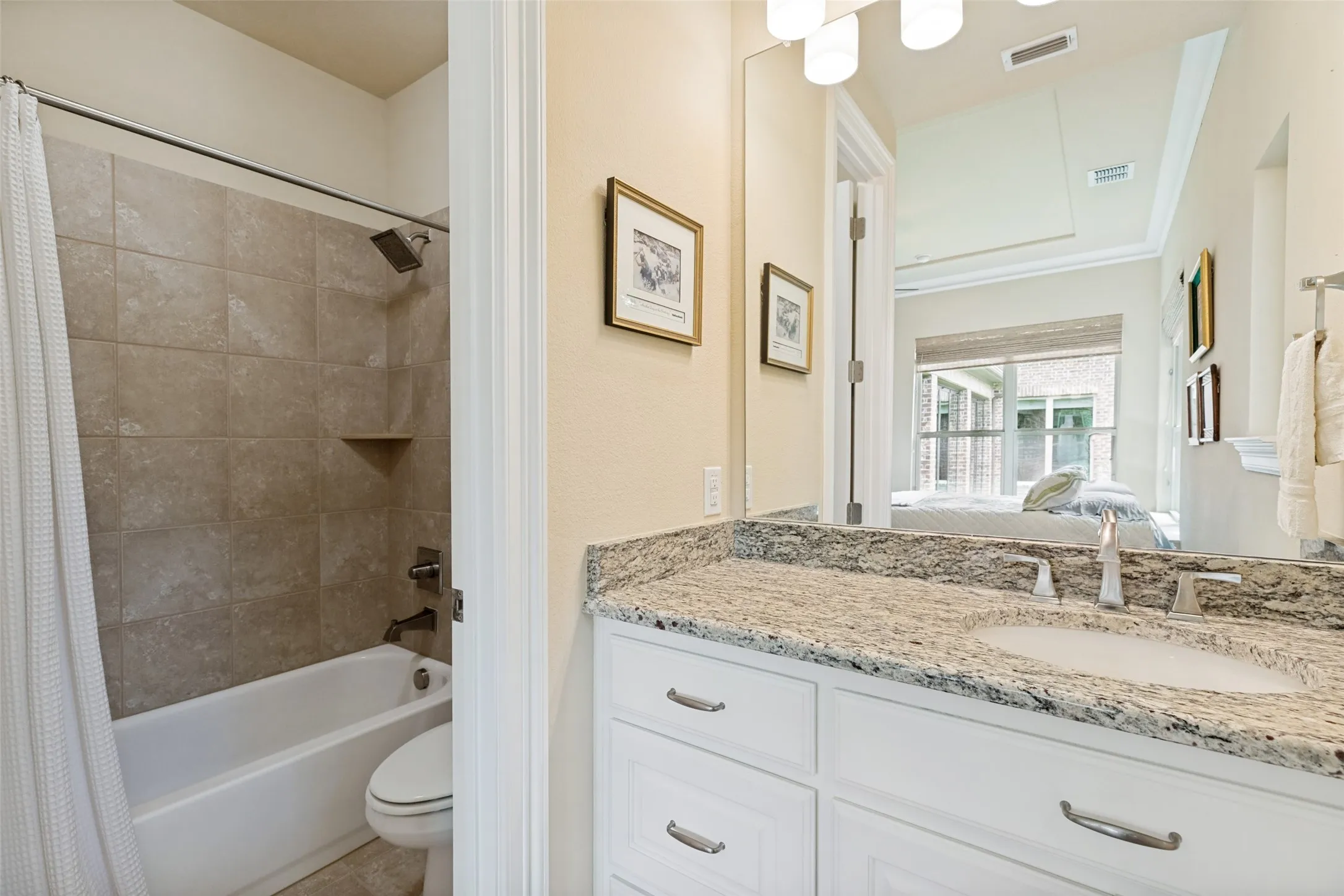 The casita bathroom is fully equipped with a wide white vanity with granite countertops, an undermount sink and hardware.  A cabinet over the toilet adds to storage.  A mirror and lights are above.  Floor tile surrounds the tub/shower, and there is a nice walk-in closet in the suite.