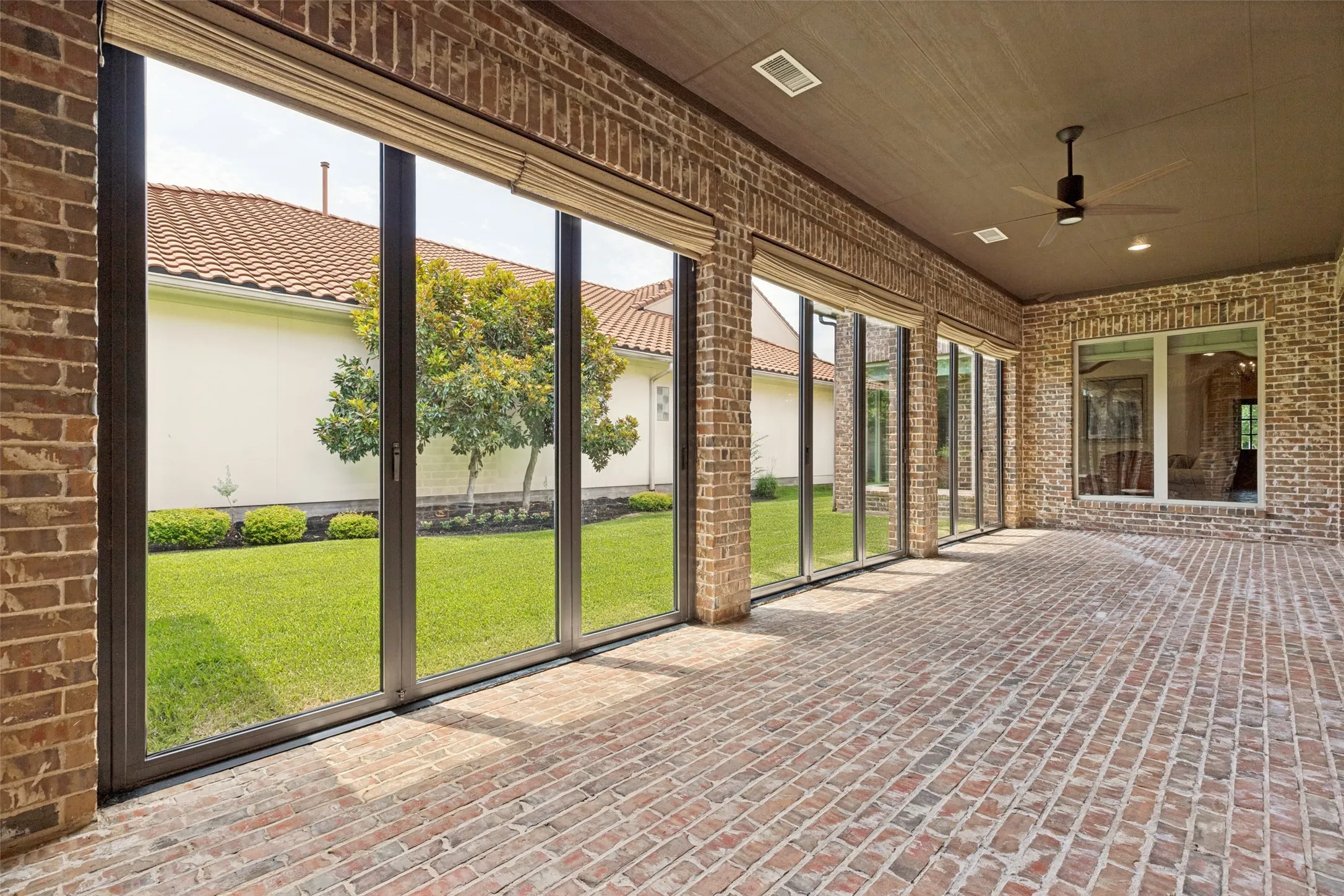 This is the perfect situation!  This huge bricked space can be an open-air patio or an enclosed climate controlled sun porch.  A bank of wide sliding doors can be opened or closed as desired.  In addition to HVAC the space can also be cooled with the ceiling fan, and there are recessed lights.  There is plenty of room for comfortable furniture and dining al fresco in this delightful space.  Access to both the casita and garage is through this area.