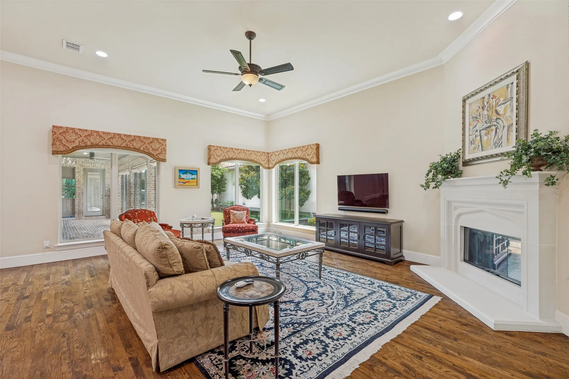 Wood floors in the family room provide a perfect setting for a pretty rug.  The cast stone fireplace with gas logs is an eye-catching focal point.