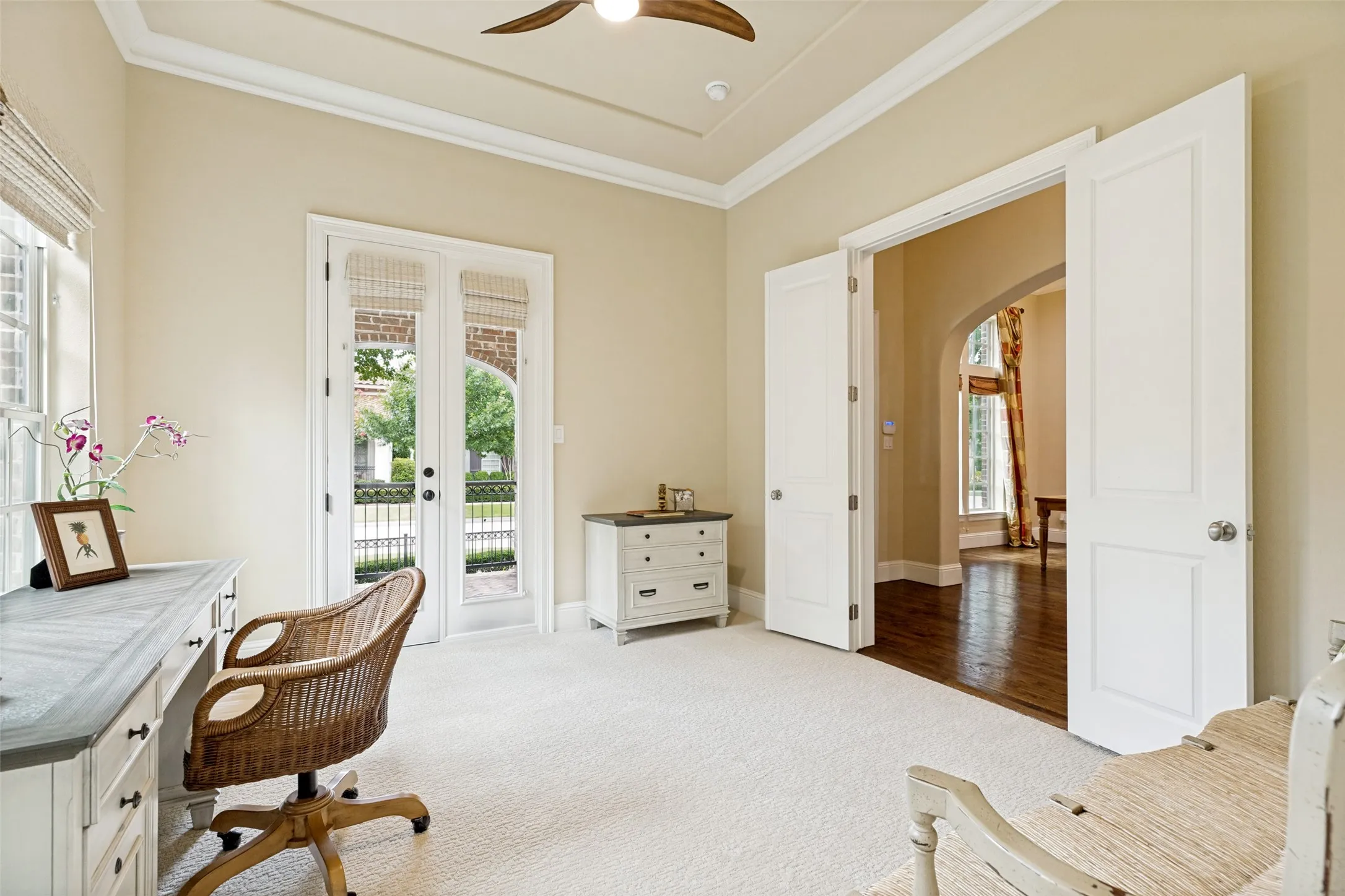 Solid double doors open to the home office from the entry, and a matching pair with glass panes and shades opens to the front porch.  Crown molding adds appeal to the room.