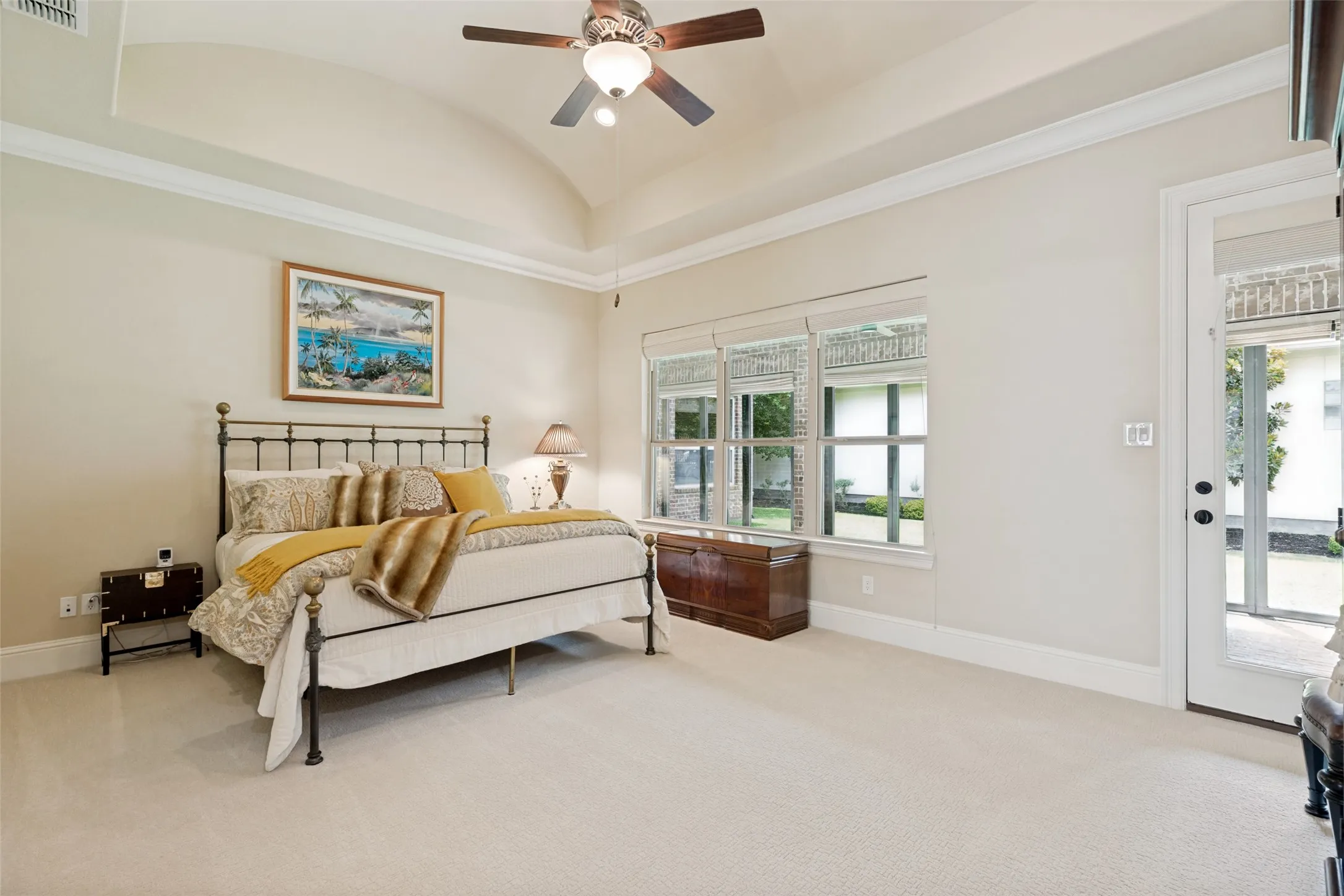 This very spacious primary bedroom will be a haven of relaxation for owners.  The tall barrel ceiling adds a special touch of aesthetic character in the room.  Soft carpet is on the floor and a breezy ceiling fan with a light is above.