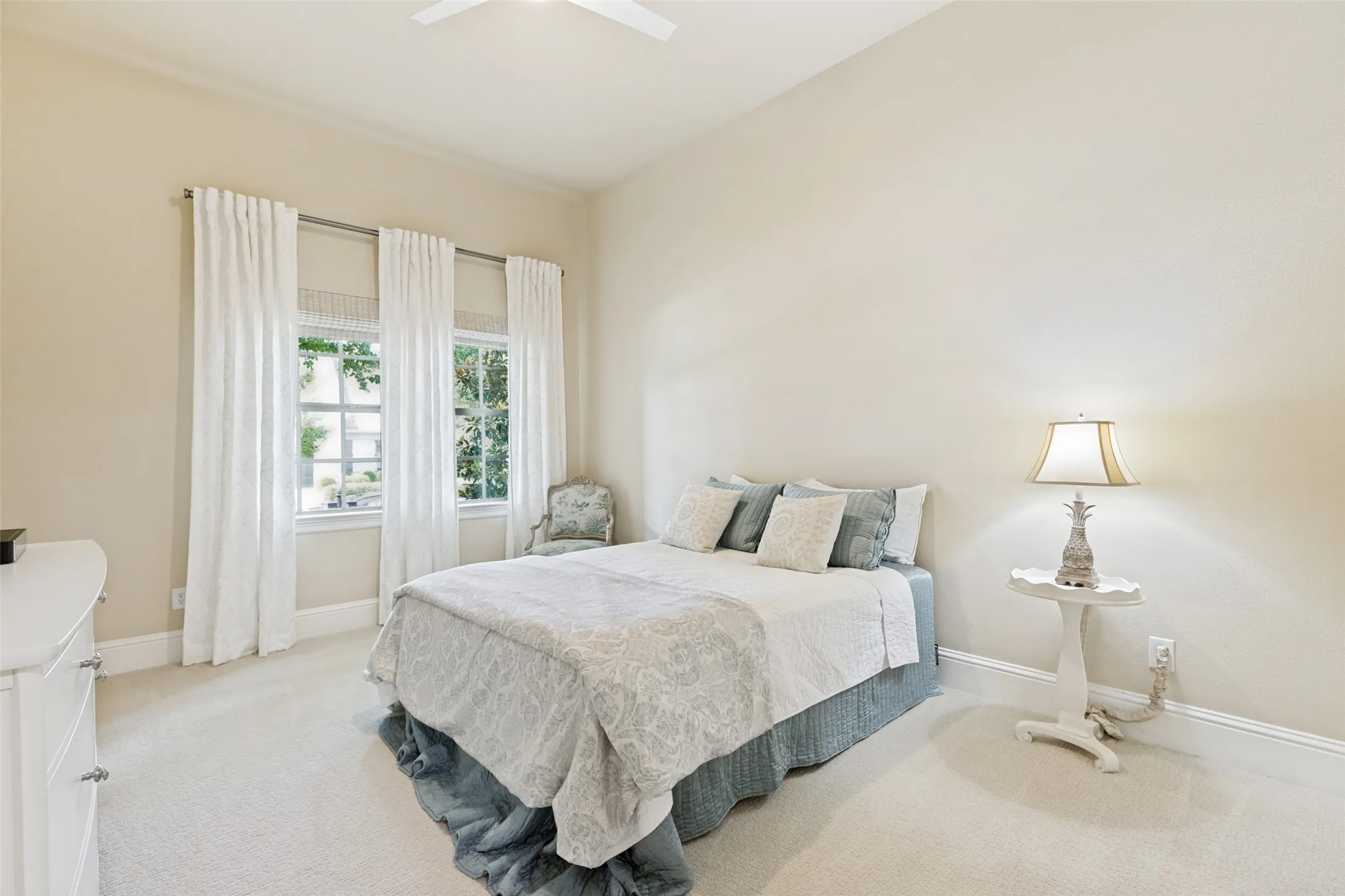 Guests will want to stay forever with this lovely suite.  The bedroom has two windows with drapes and shades, a tall ceiling with a lighted fan and soft carpet on the floor.