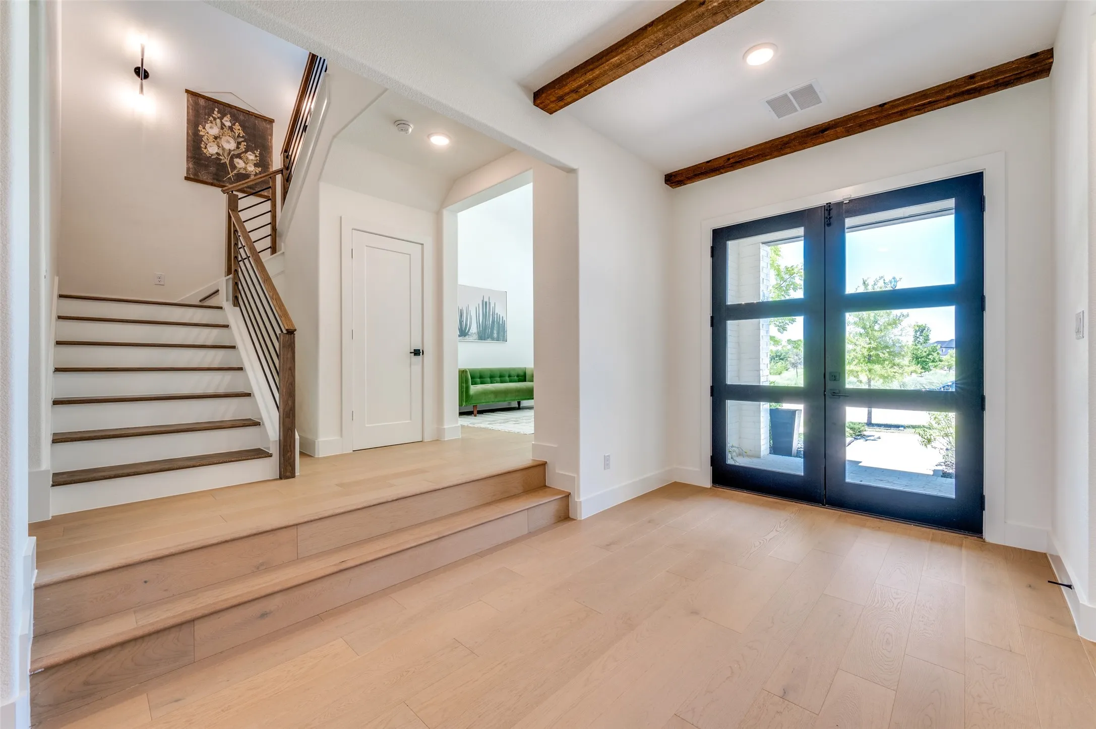 A dramatic entry with exposed beams, white oak flooring and abundant natural light sets the tone for the designer finishes found throughout.