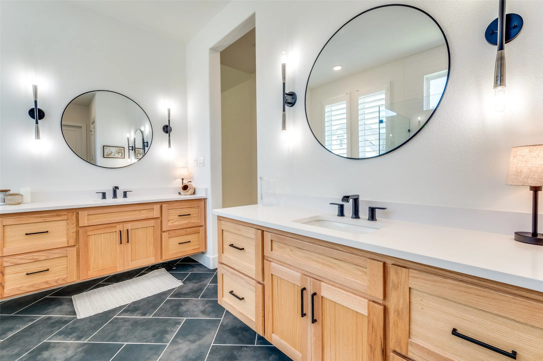 Spa-inspired bath featuring floating furniture-style vanities, under-cabinet accent lighting and quartz countertops.
