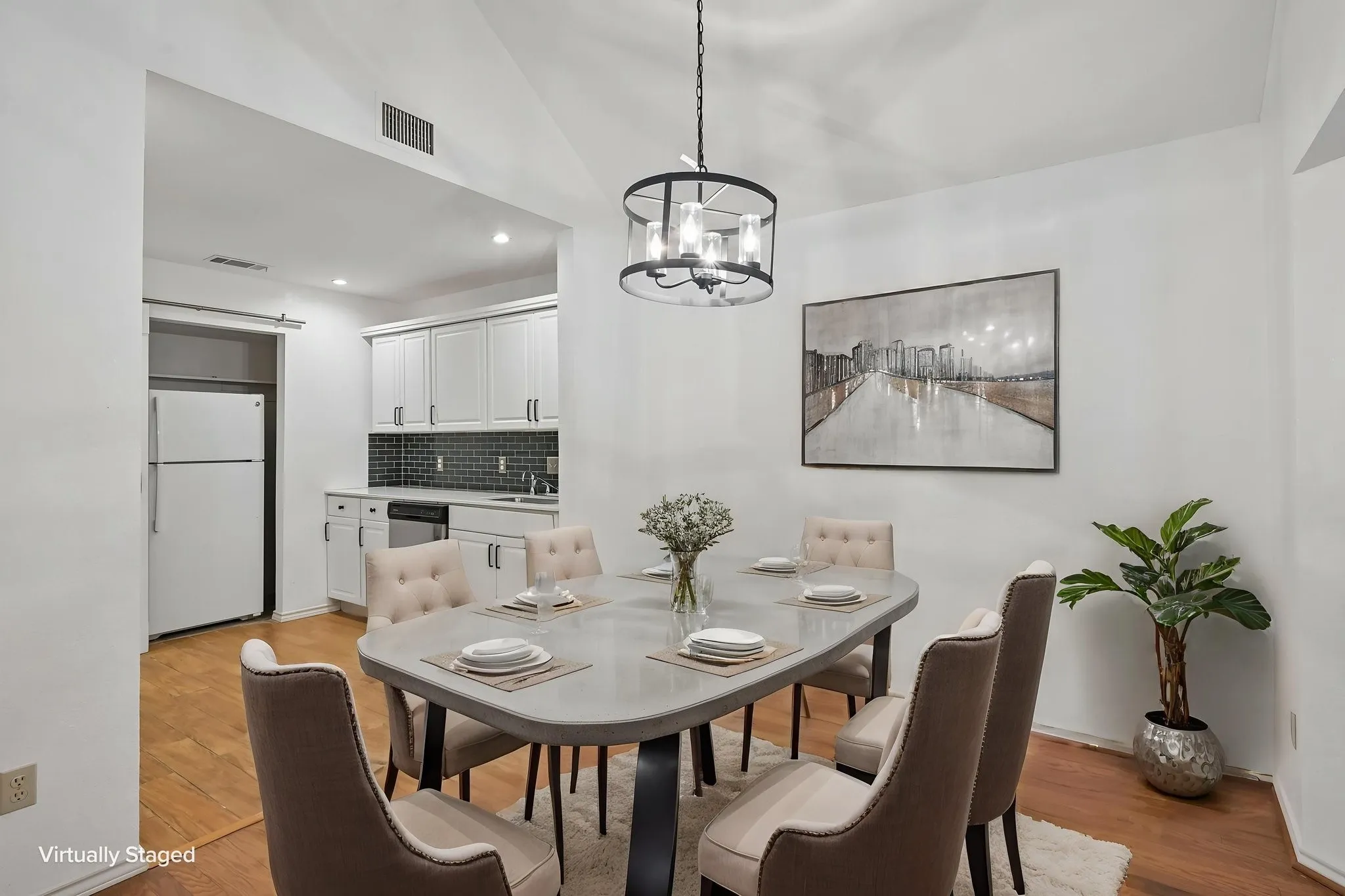Dining area featuring wood-finish flooring, a contemporary chandelier, and a vaulted ceiling