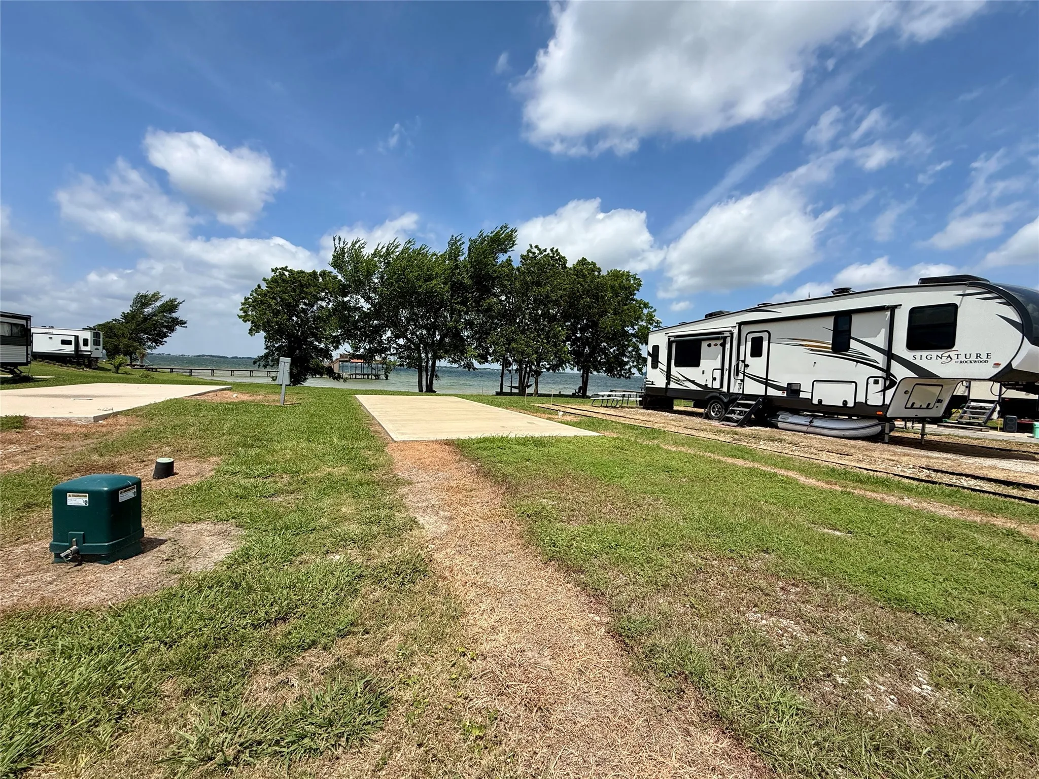 Improved lot with pad, utilities available, and shade.