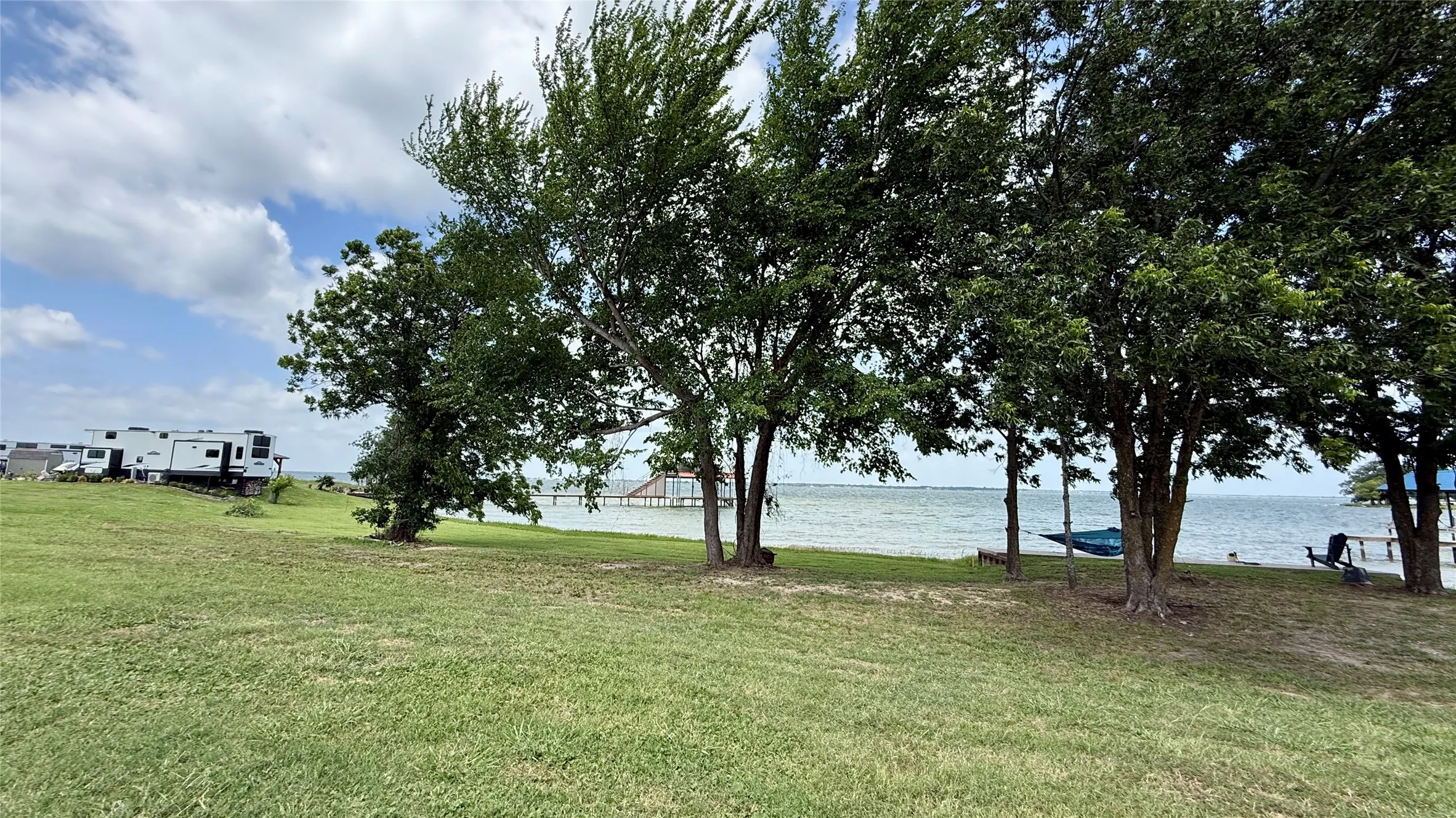 Mature trees provide shade near the shoreline.