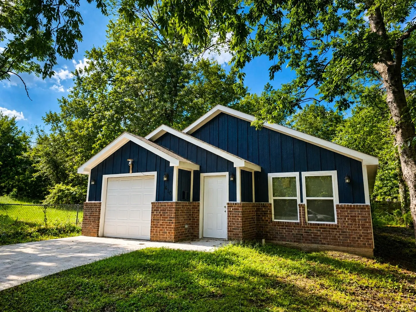 Contemporary exterior featuring blue vertical siding and brick veneer