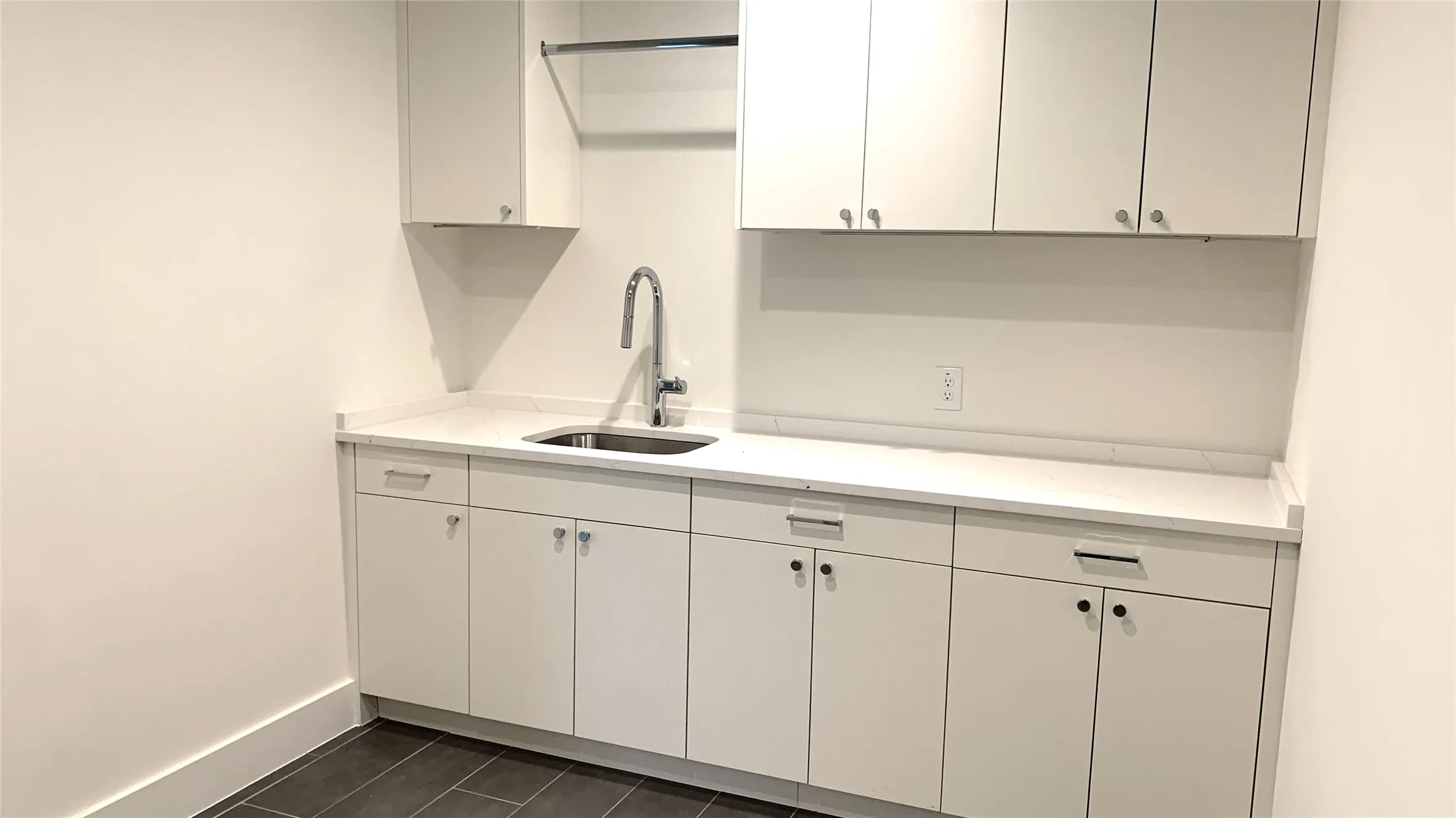 Large Laundry Room with lots of cabinets, sink, dripping area and counter space