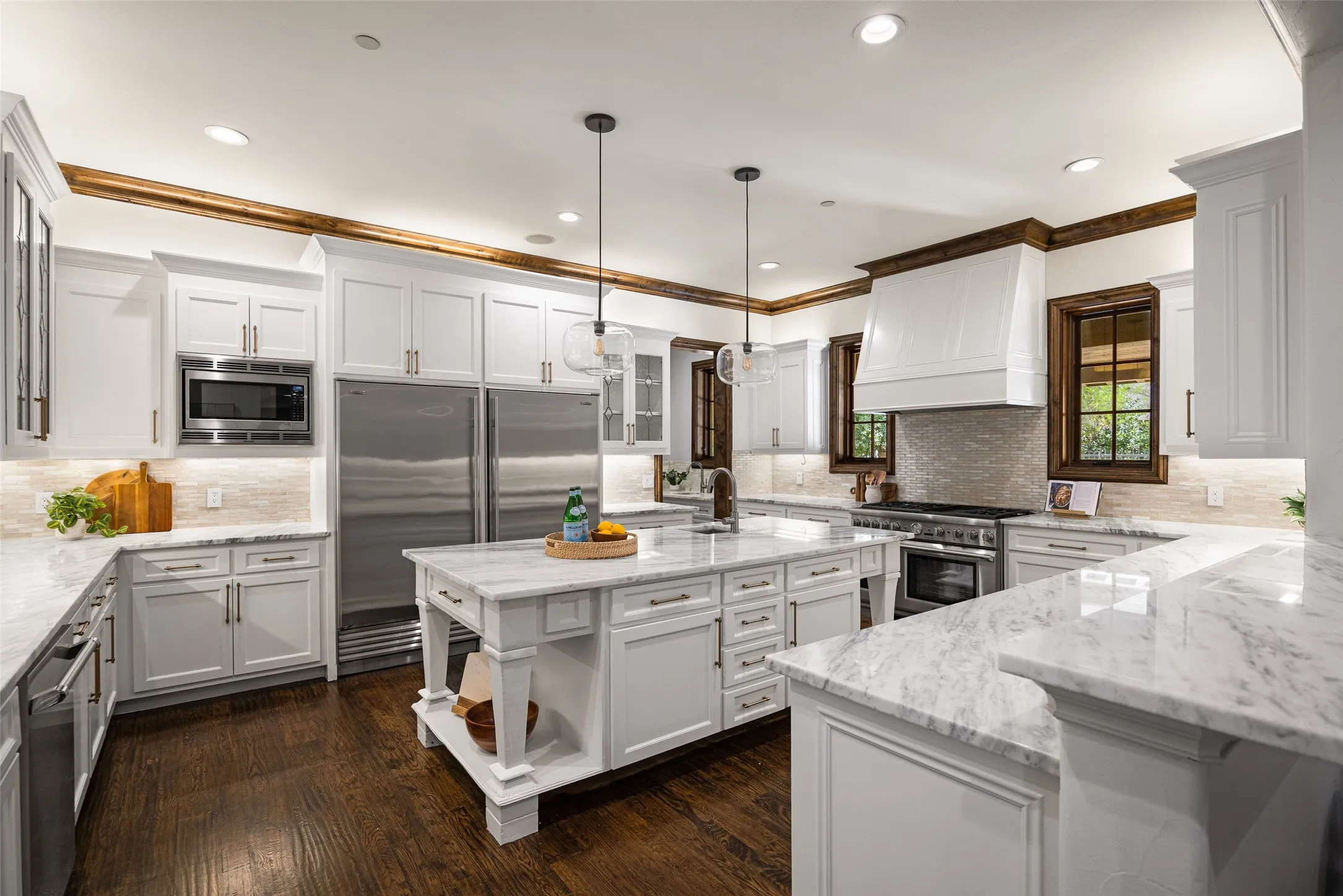 Kitchen featuring a central island, white shaker cabinetry, stainless steel appliances, and dark wood-finish flooring