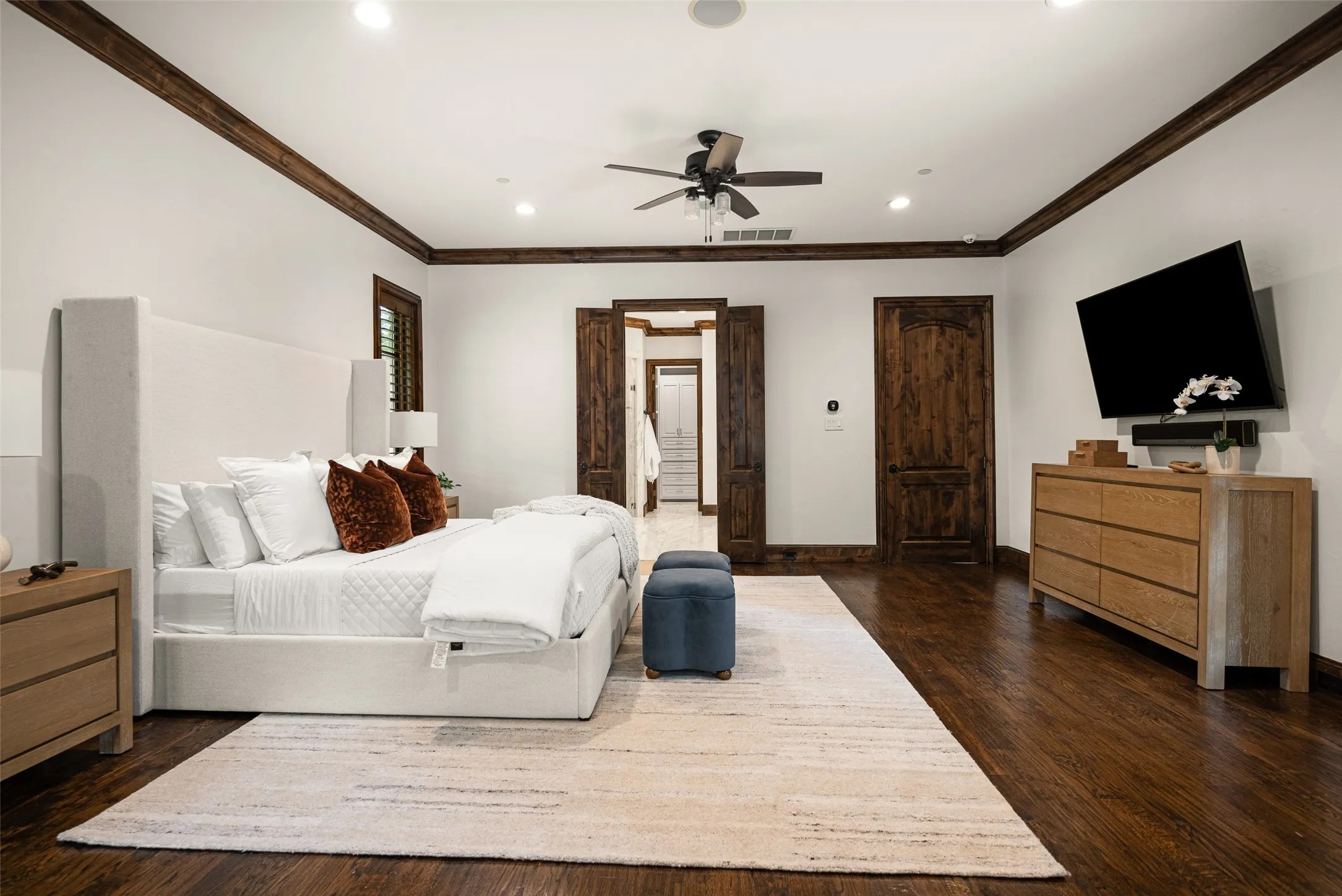 Spacious room featuring rich wood-finish flooring and crown molding