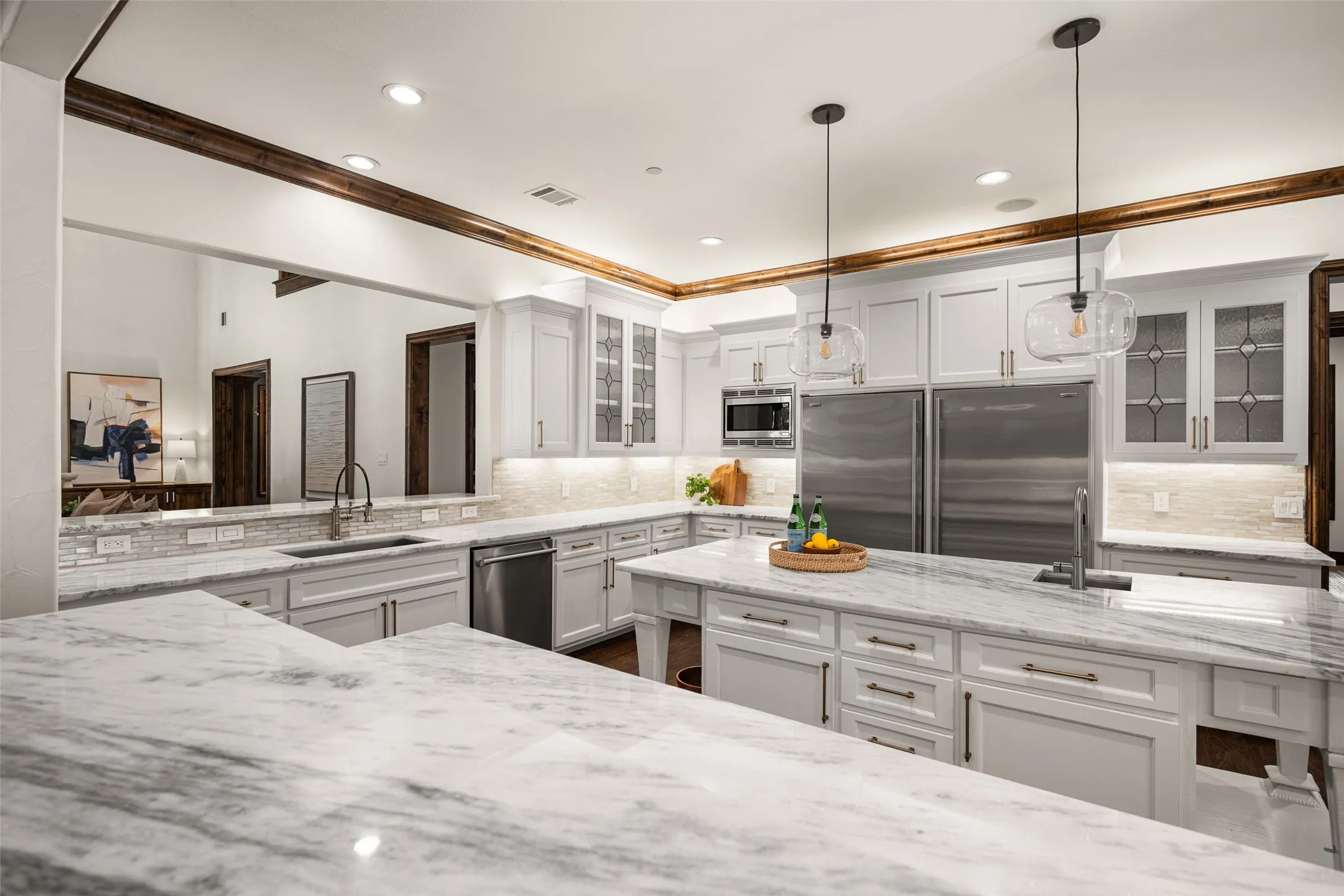 Spacious kitchen featuring extensive white cabinetry, marble-look countertops, and a full suite of stainless steel appliances