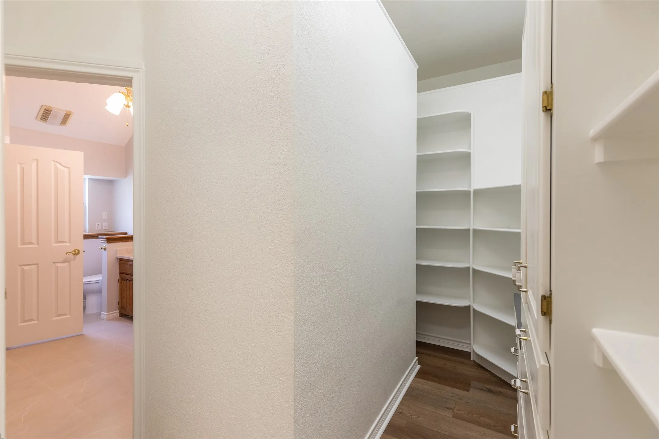 Dressing area has built in dresser, an abundance of shelves, overhead storage, make up dresser and plenty of electrical outlets.