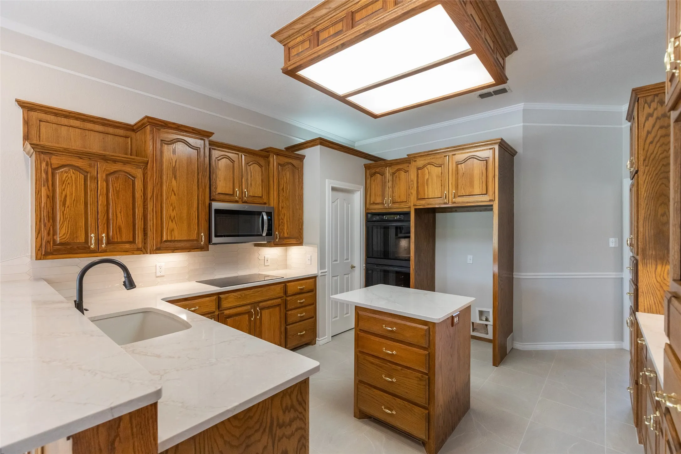 Spacious and auto-lighted pantry by ovens, quartz counters and 17 inch tile installed April 2026.