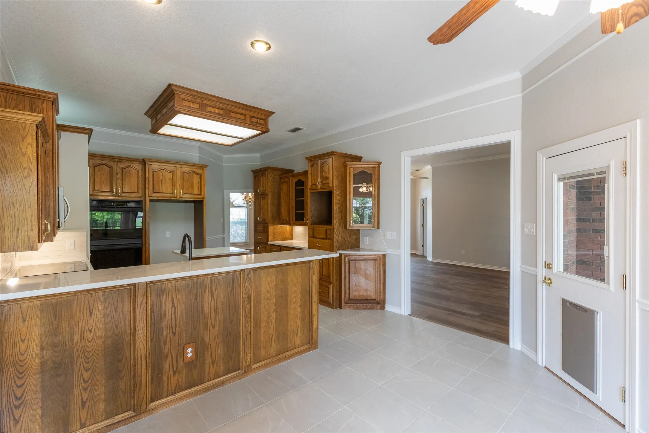 From breakfast area, notice spacious high bar into kitchen. Large dog door in back door that leads to covered patio