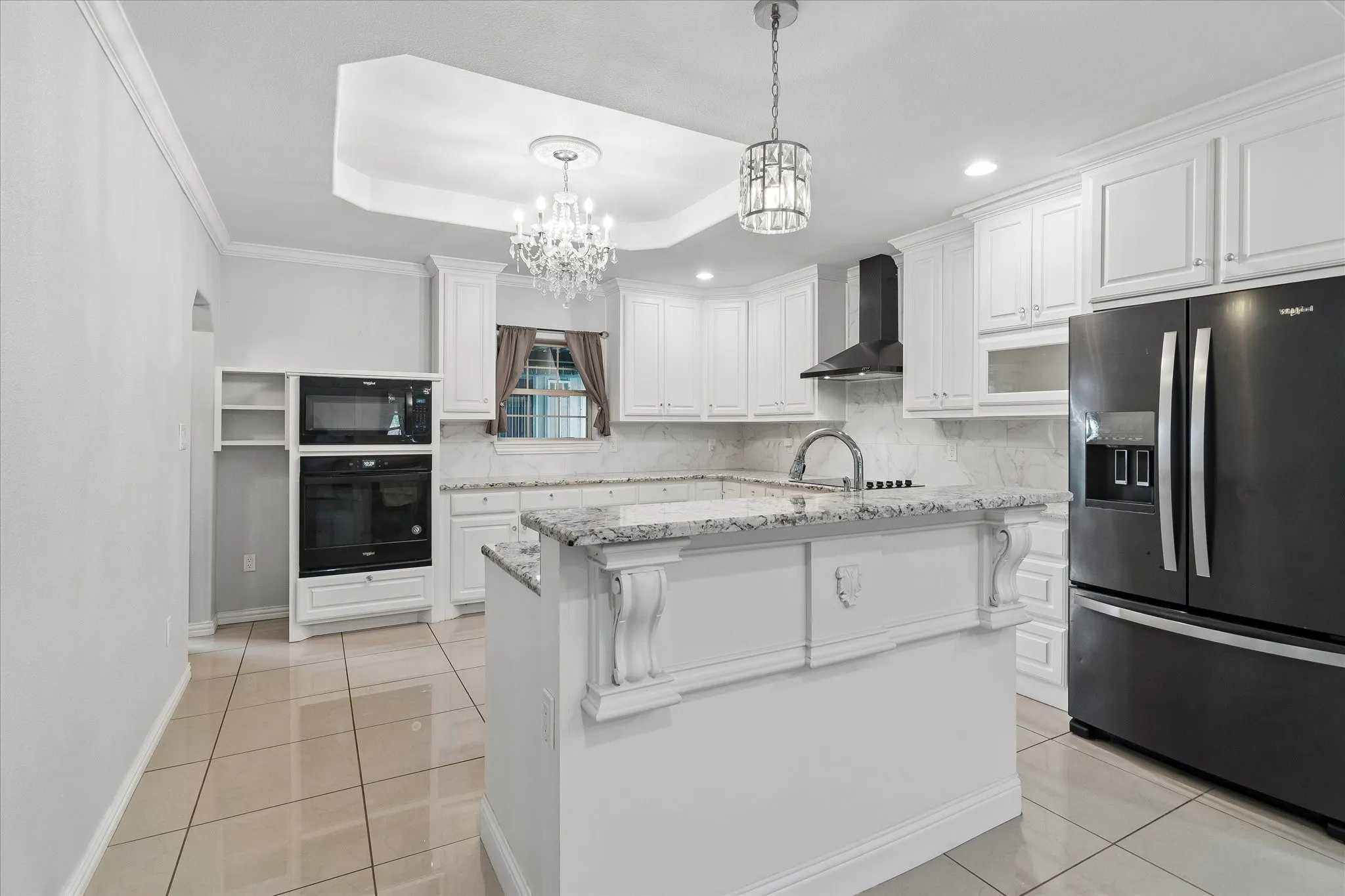 Contemporary kitchen featuring white cabinetry, light-toned tile flooring, and contrasting black appliances
