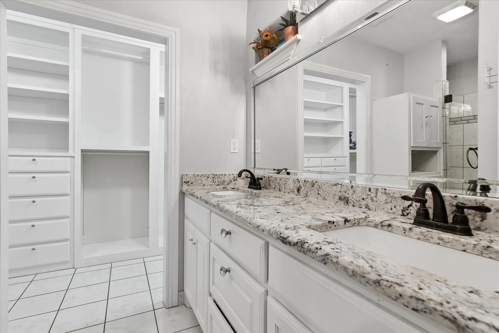 Dual vanity with integrated sinks, granite countertops, and dark bronze fixtures