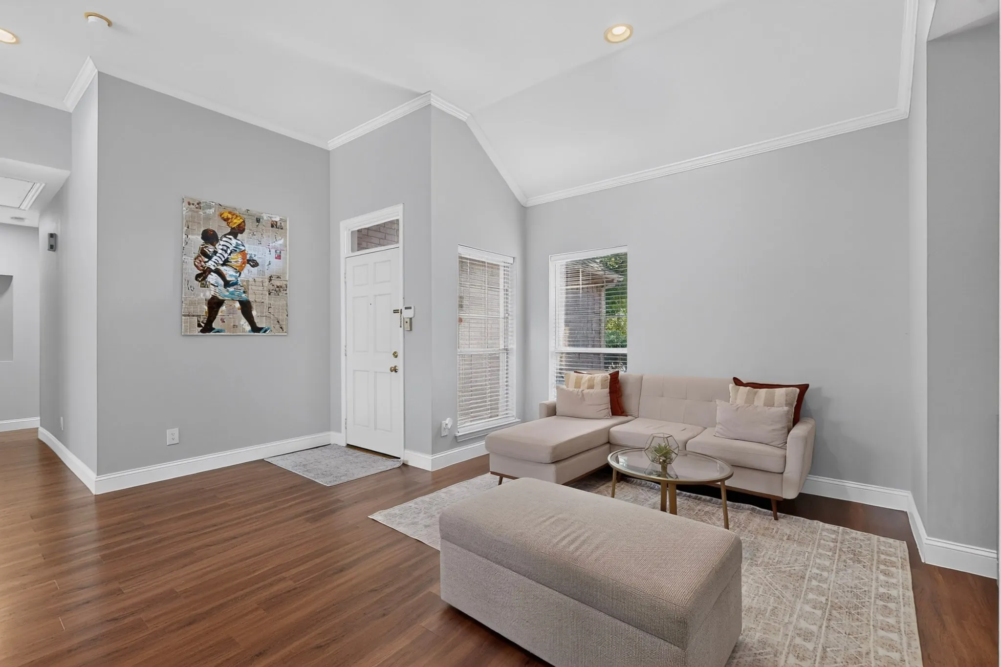 Welcome! Living area featuring vaulted ceilings, recessed lighting, wood-finish flooring, and white trim