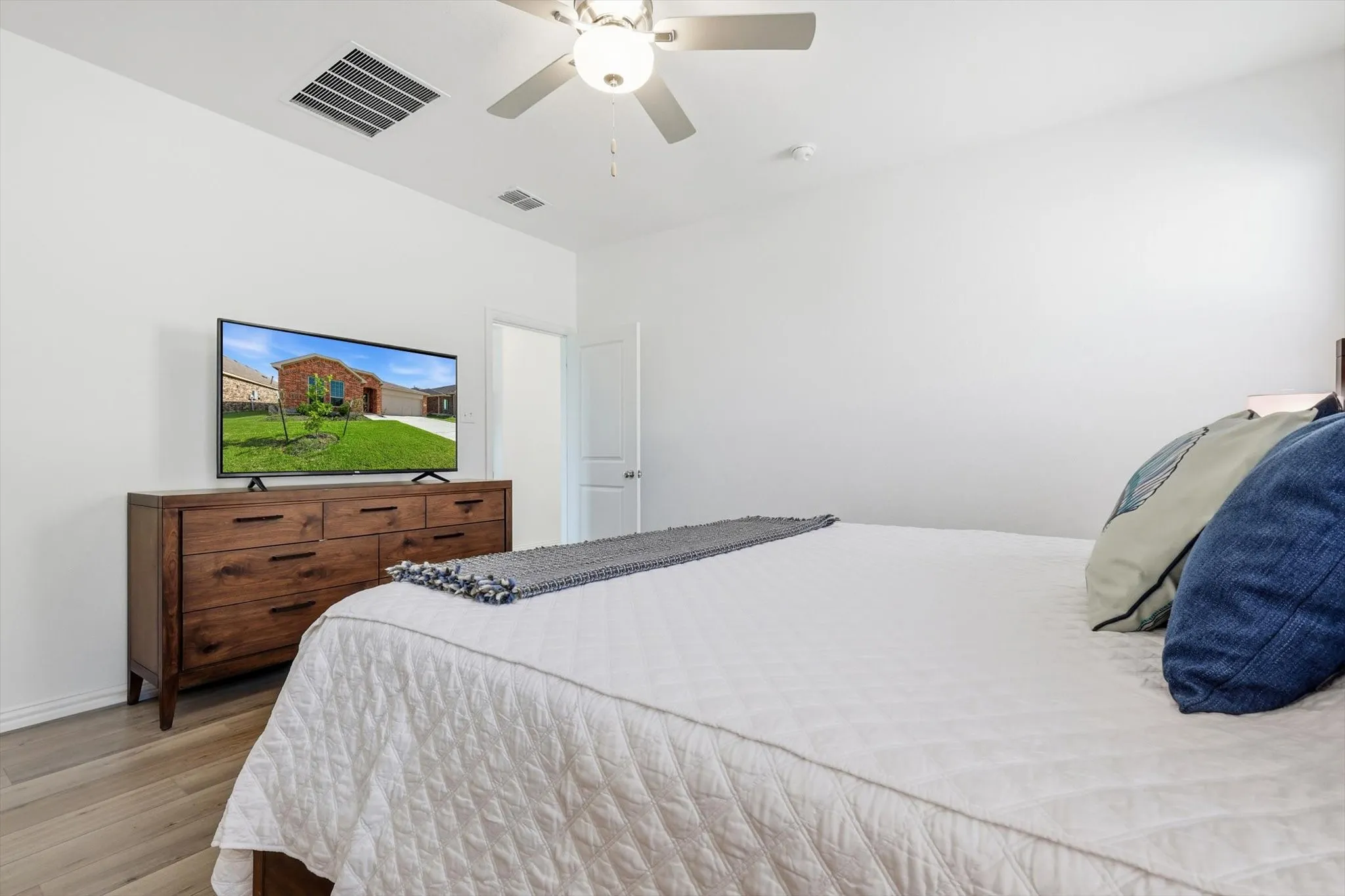 Spacious with a king-sized bed, dresser and chair.