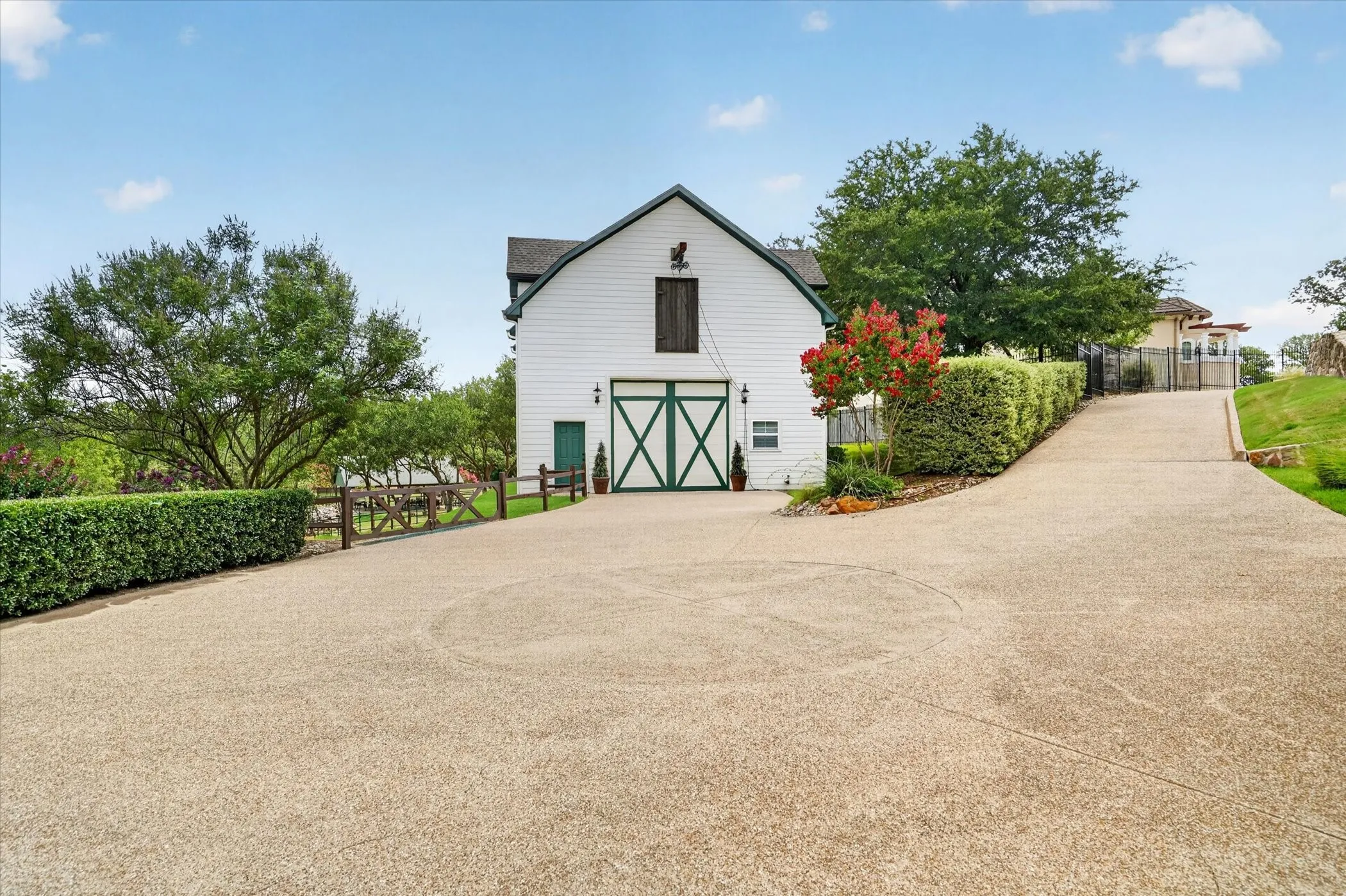 White barn-style structure with dark green crossbuck doors