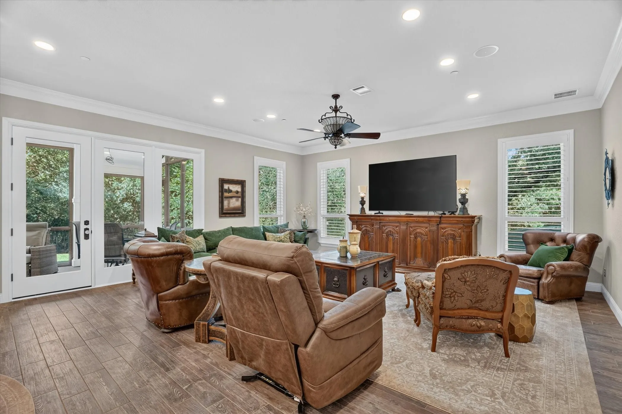 Spacious living area featuring wood-finish flooring, recessed lighting, and crown molding