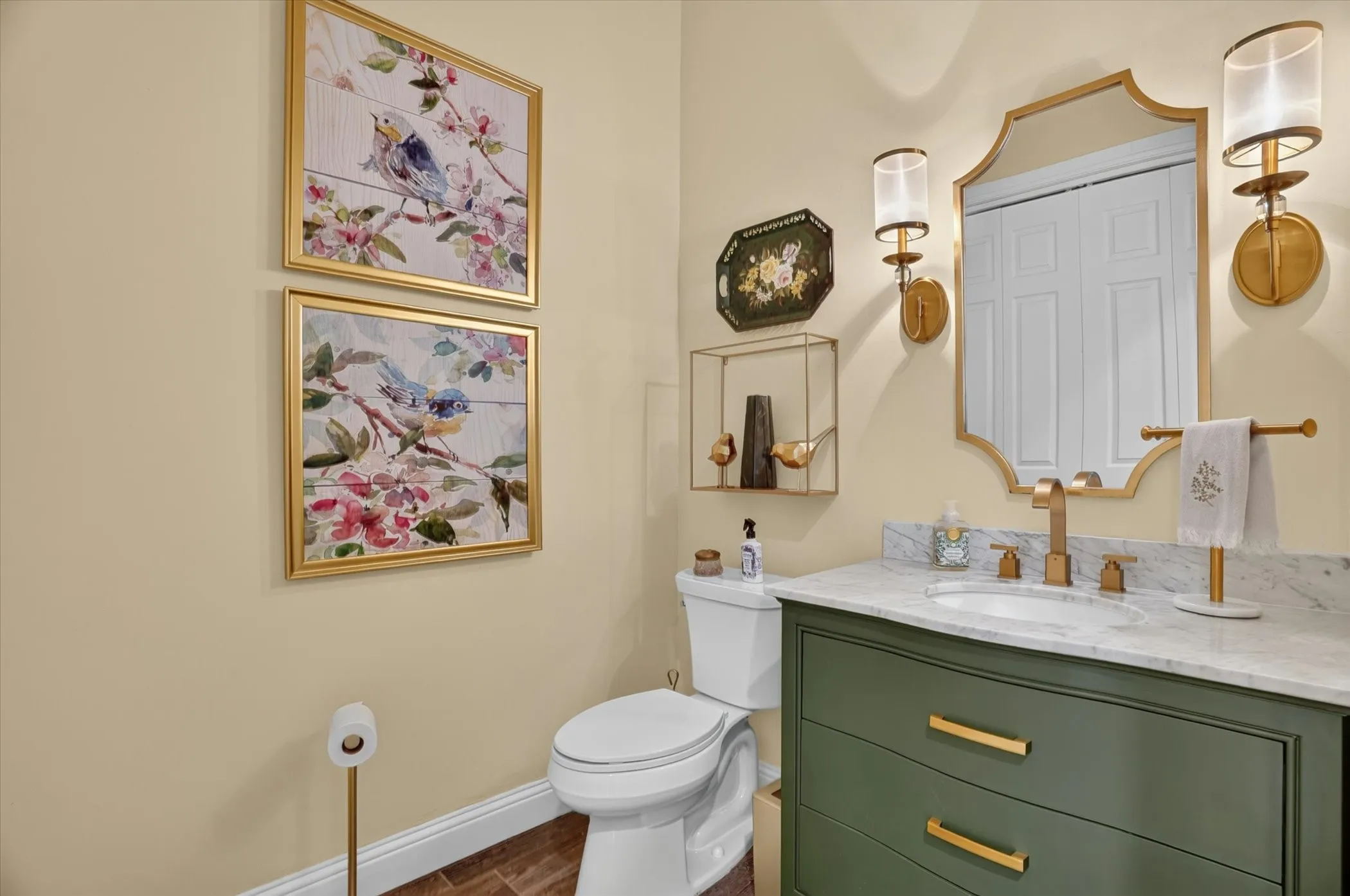 Bathroom featuring a green vanity with brass hardware, a white undermount sink, and a stone countertop
