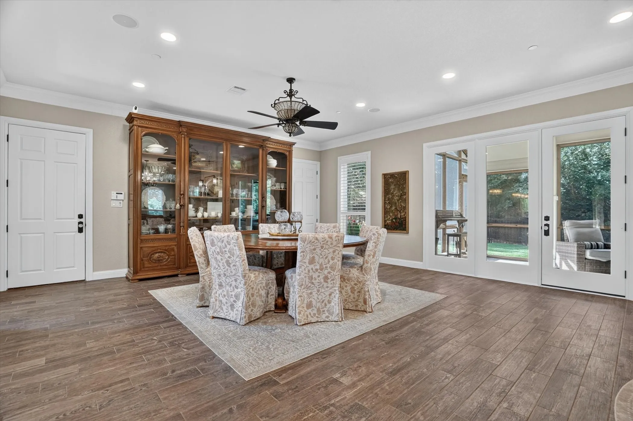 Spacious dining area featuring wood-finish flooring, recessed lighting, and a decorative ceiling fan