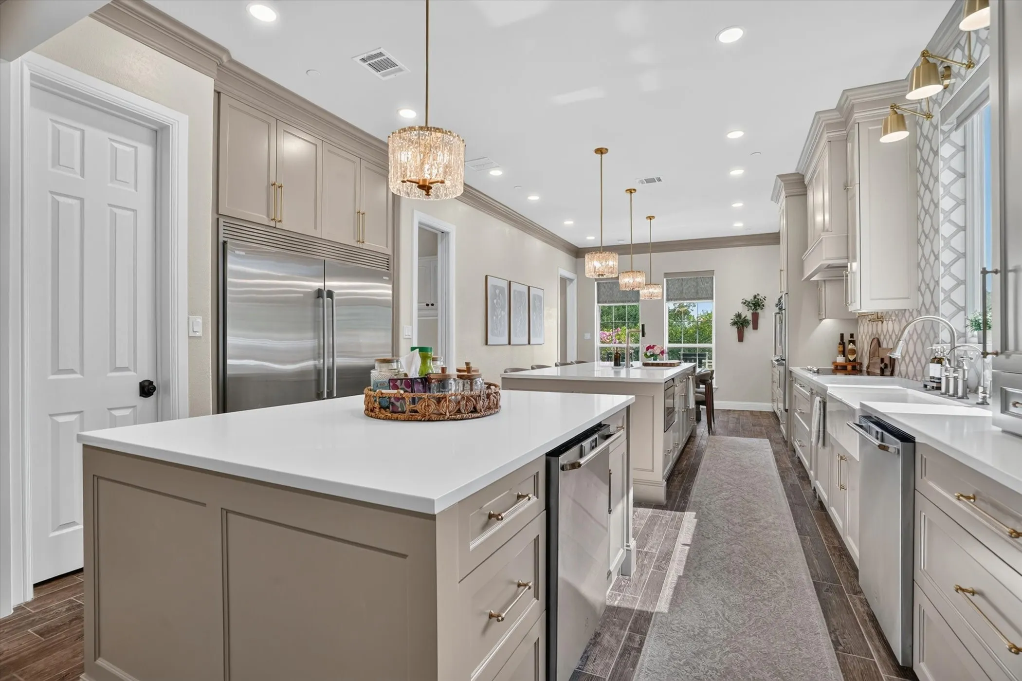 Gourmet kitchen featuring two islands with white countertops, stainless steel appliances, recessed lighting, and decorative pendant fixtures