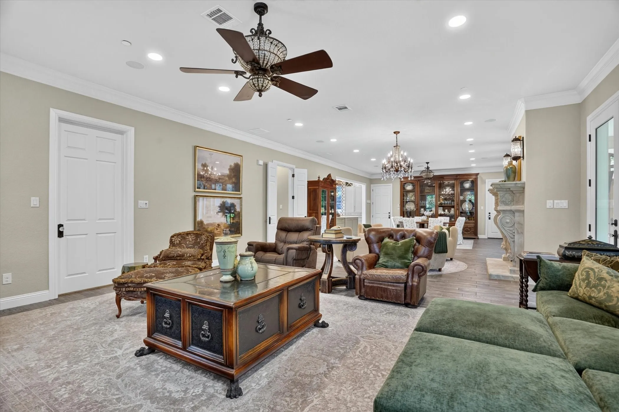 Spacious living area featuring crown molding, recessed lighting, and a decorative ceiling fan