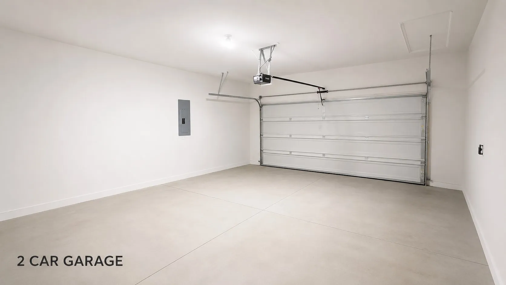 Spacious garage featuring a light concrete floor, bright white walls, and a large overhead door