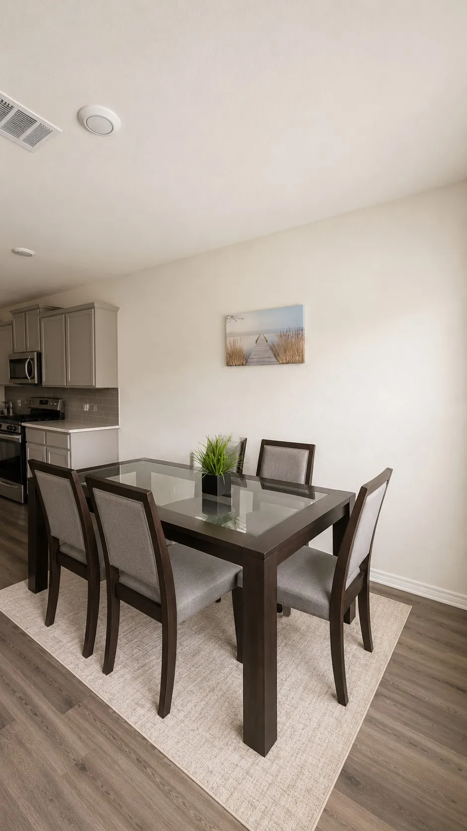 Open-concept dining area featuring wood-finish flooring and light-toned walls