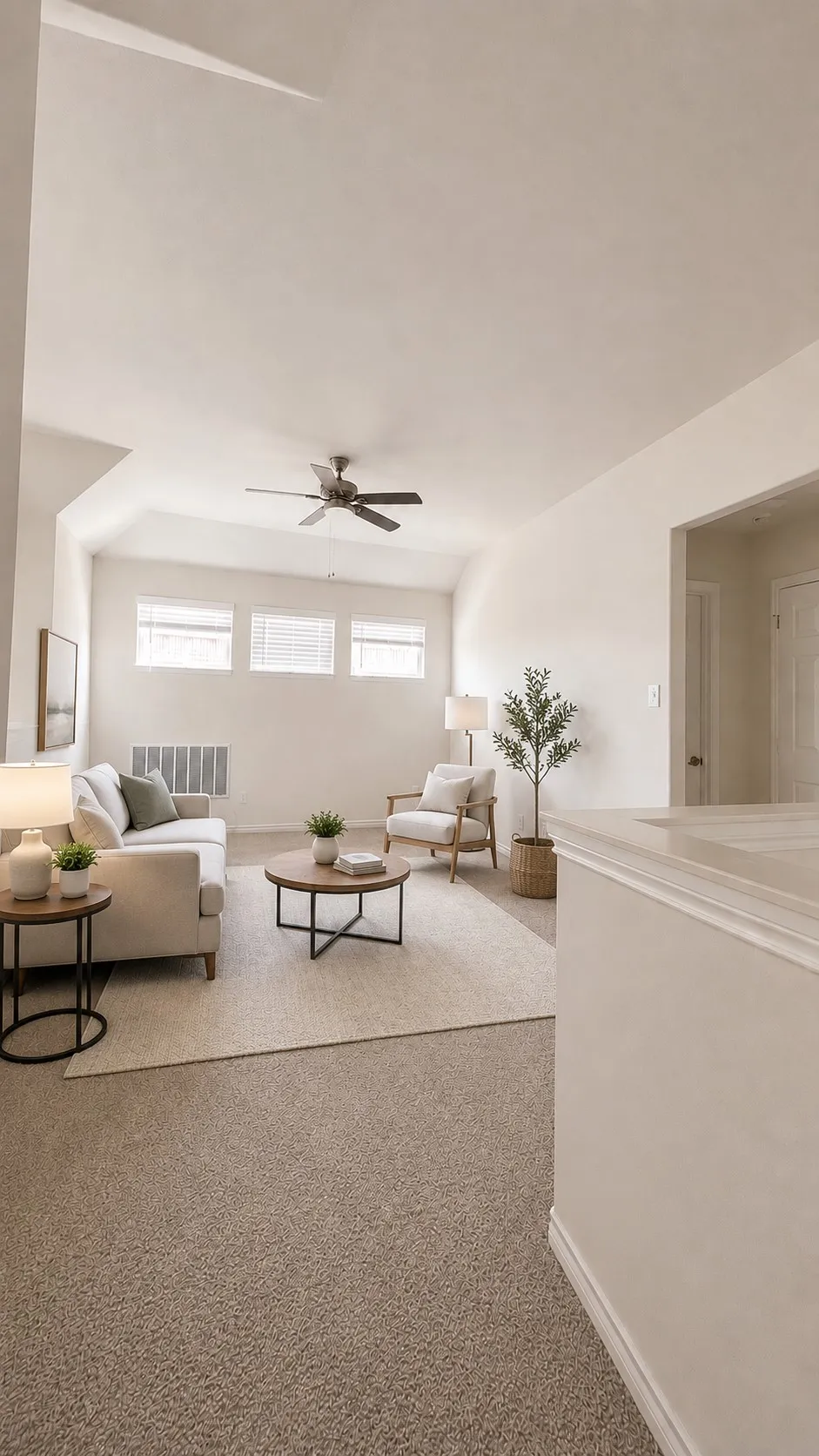 Carpeted loft area featuring a vaulted ceiling with a ceiling fan