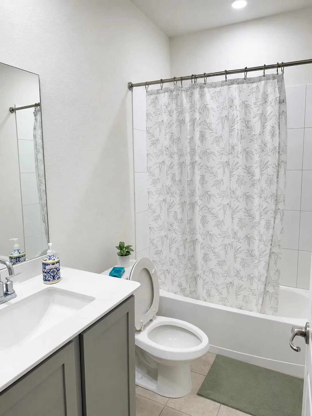 Bathroom featuring a single-sink vanity with gray cabinetry, a white countertop, and a chrome faucet