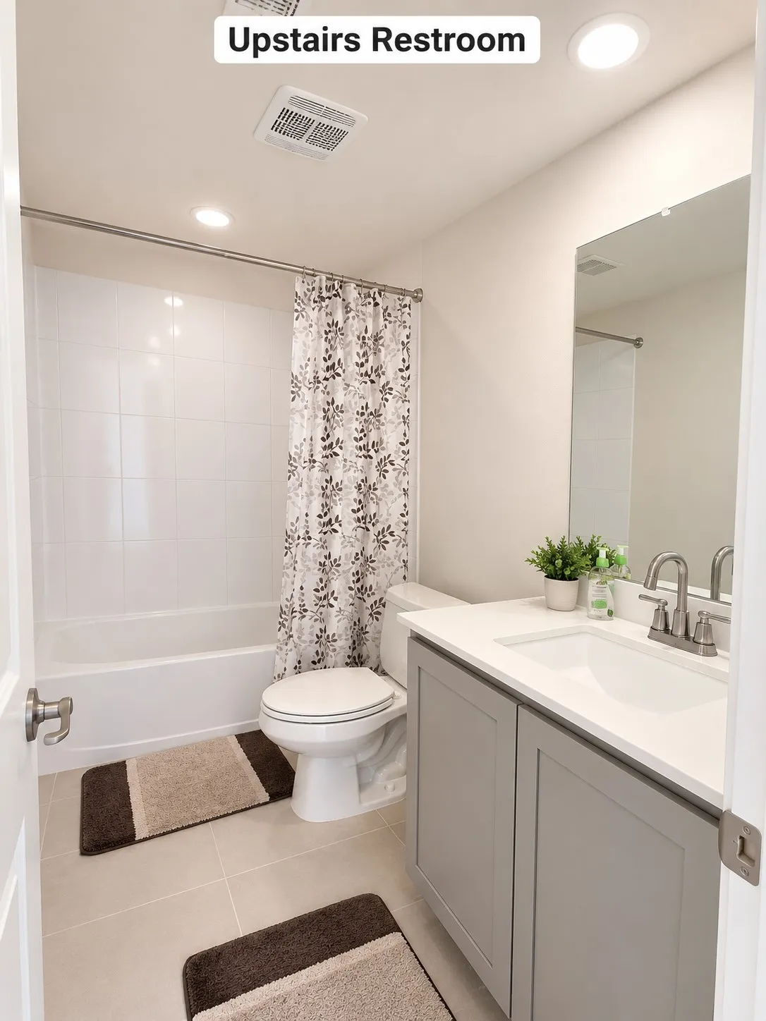 Bathroom featuring a built-in tub with white tile surround, a single vanity with a white countertop and undermount sink, a large mirror, and recessed lighting