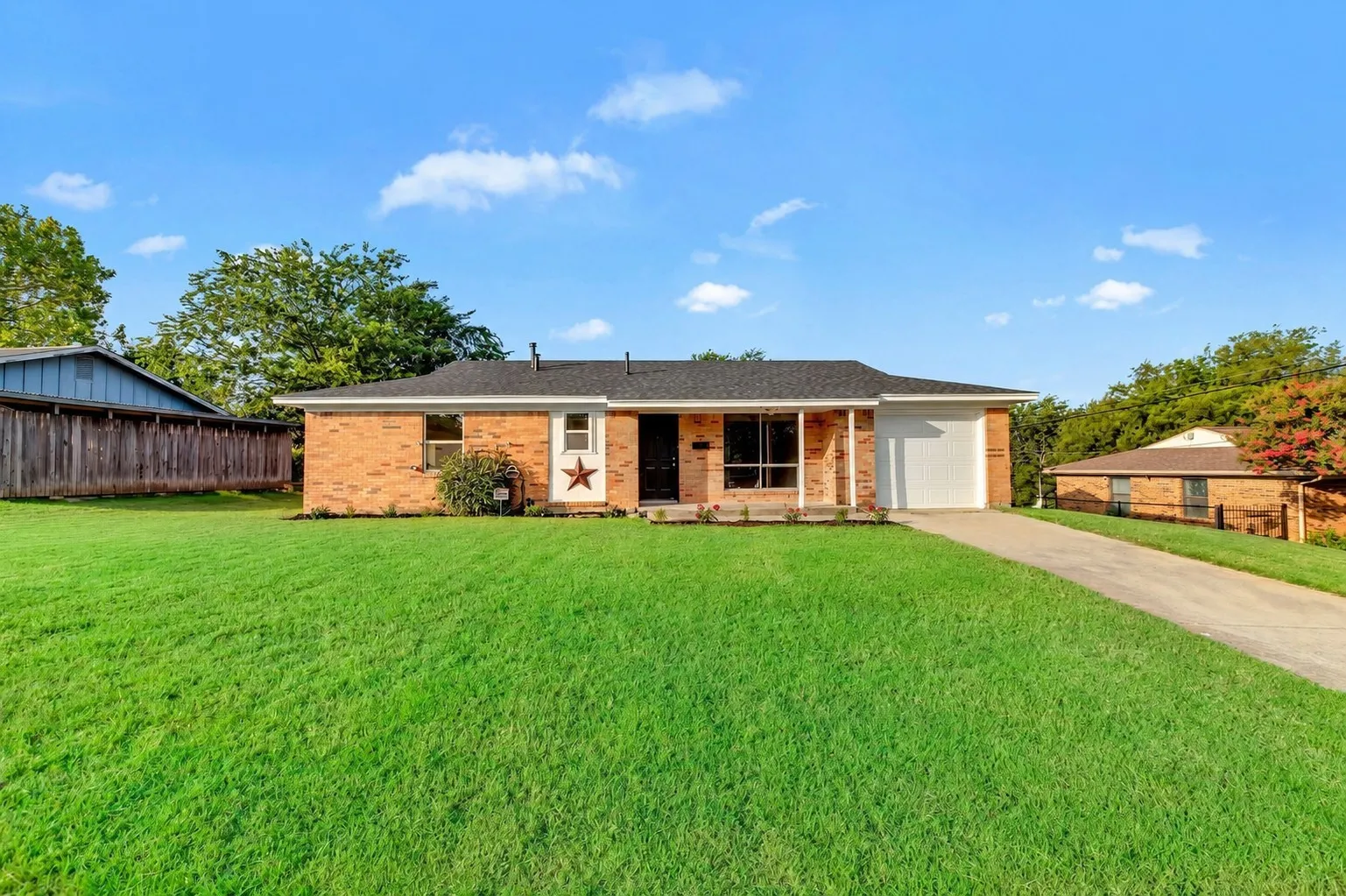 Brick exterior with an attached garage, covered entryway, and a concrete driveway