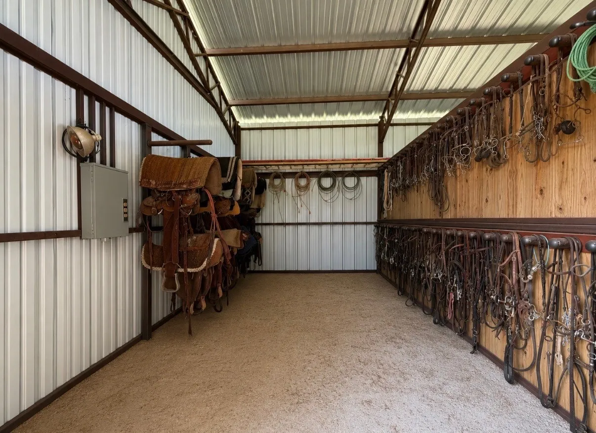 Open-sided barn structure featuring a corrugated metal roof and walls