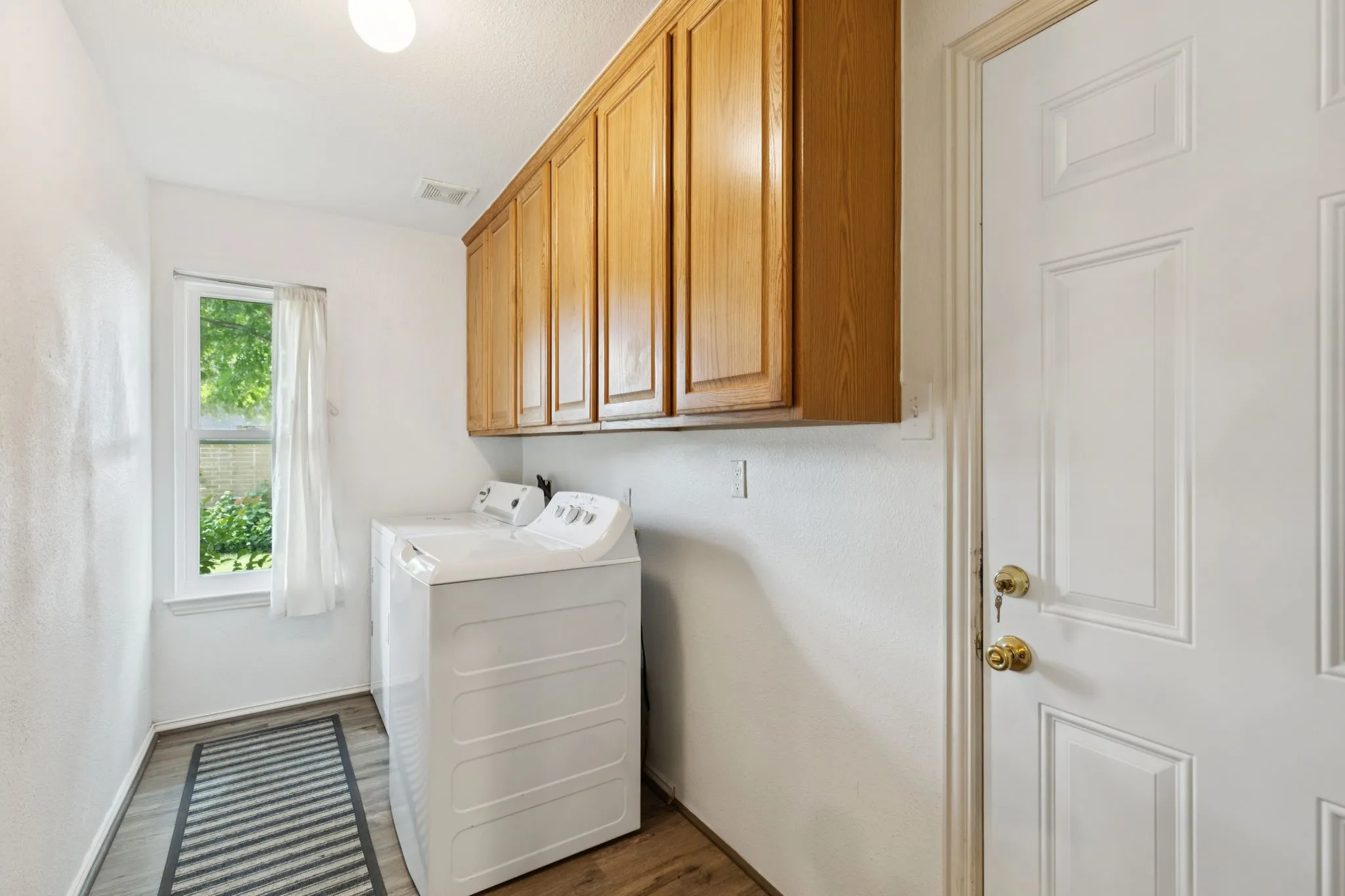 Spacious utility room has space for full size washer and dryer and a freezer! There is wonderful storage as well.