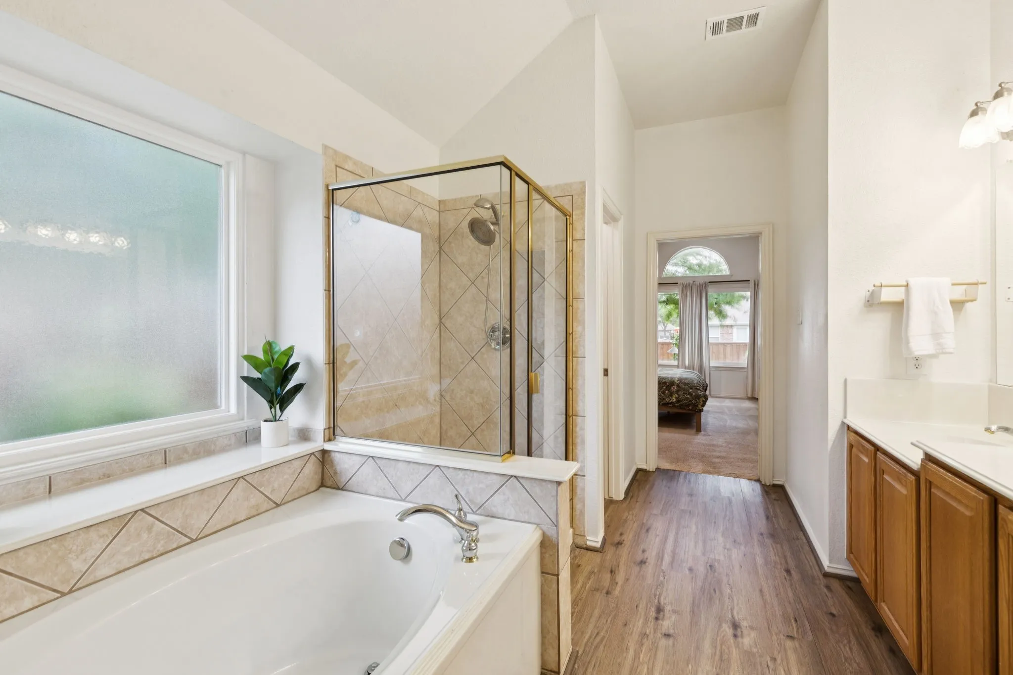 View of the primary bathroom with garden tub with Split secondary bedroom. ledge - a wonderful space to relax after a long day.